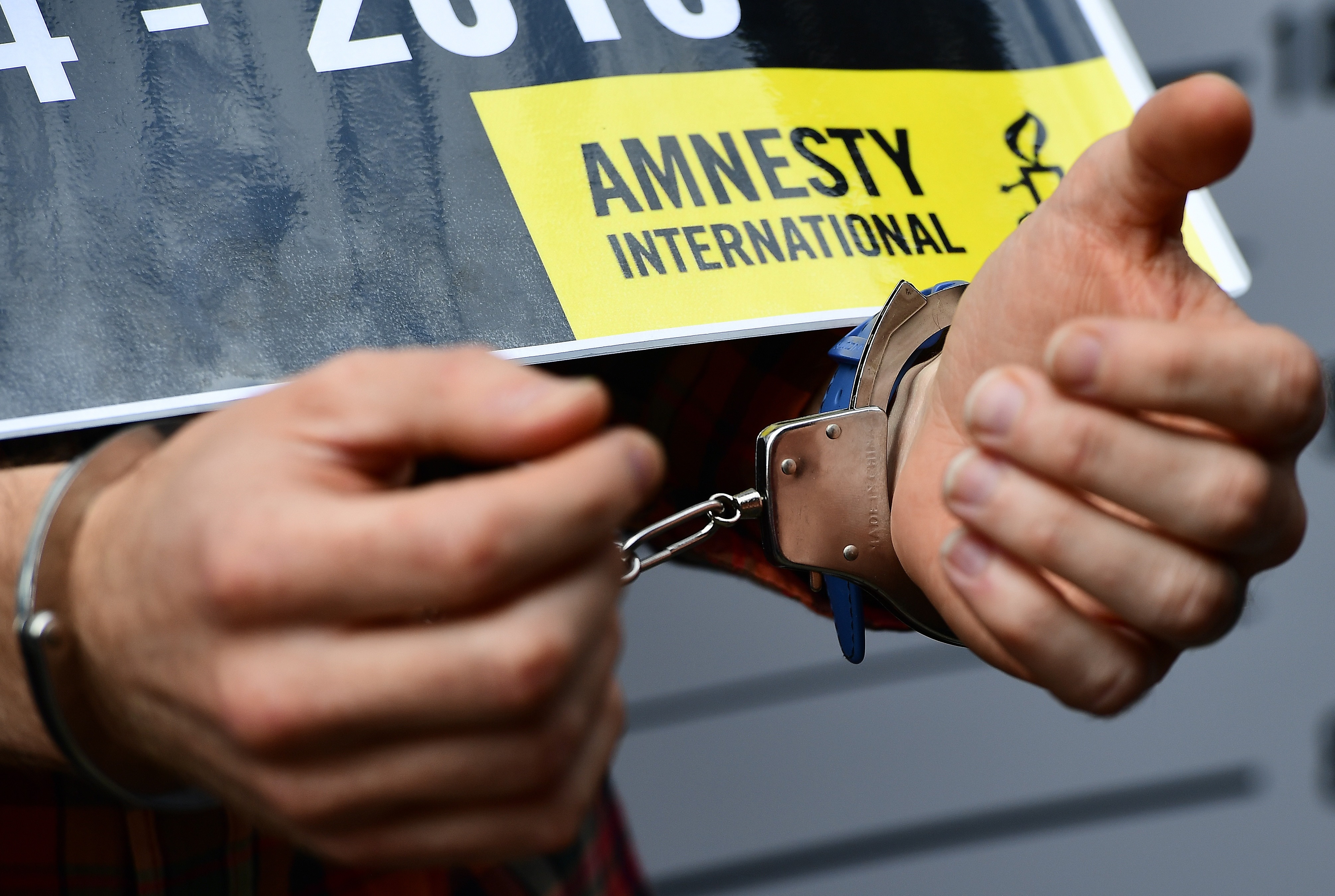 Current co-Chairman of Amnesty International in Belgium Francois Graas takes part in a mock arrest in front of the Turkish embassy to protest against the detention of the head of Amnesty International in Turkey. (Emmanuel Dunand -
                       AFP / Getty Images)