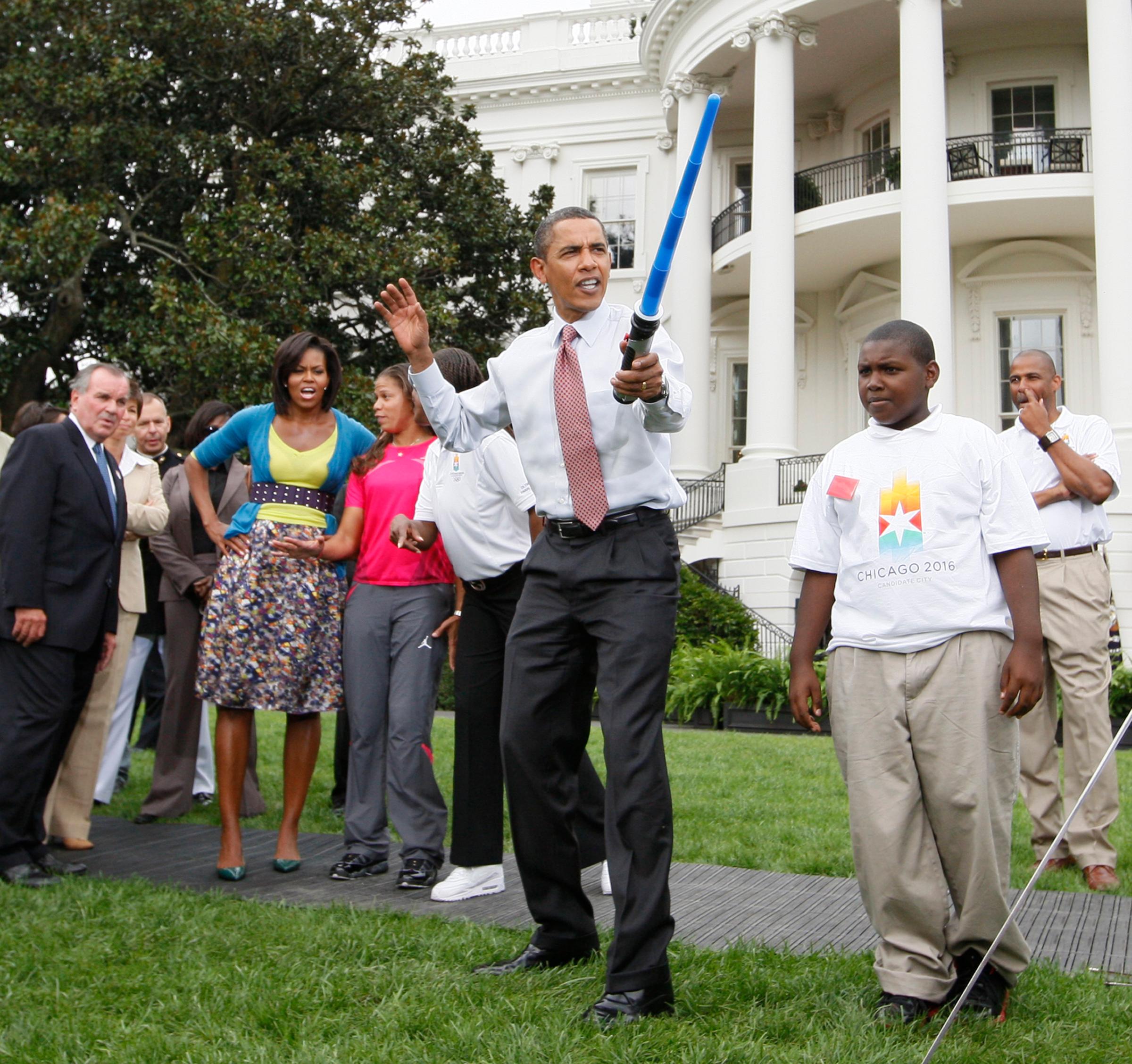 President Barack Obama uses a light saber as he watches a demonstration of fencing at an event supporting Chicago's 2016 host city Olympic bid, Wednesday, Sept. 16, 2009, on the South Lawn of the White House in Washington.
