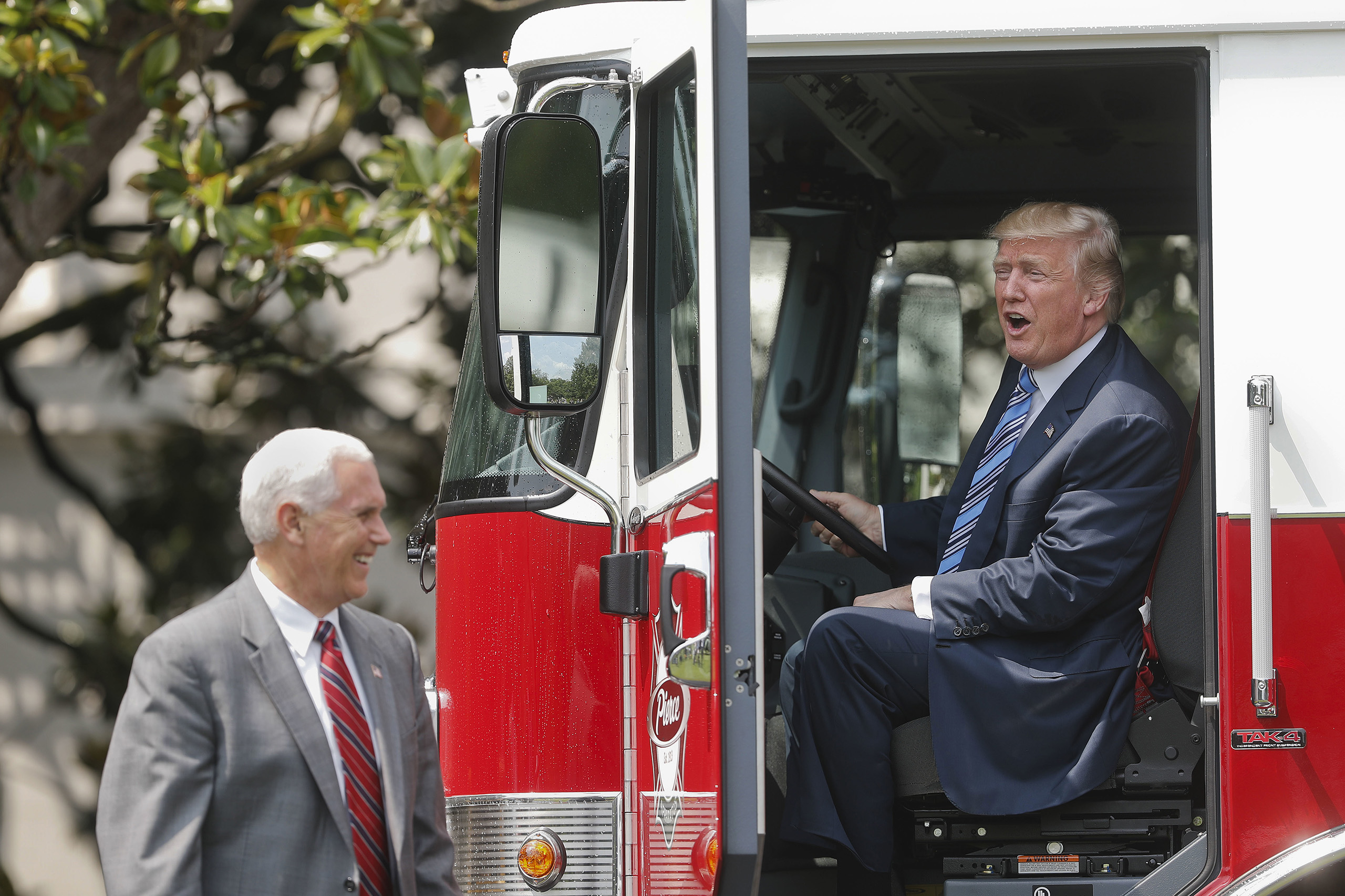 President Donald Trump, accompanied by Vice President Mike Pence, sits inside a cabin of a firetruck during a  Made in America,  product showcase featuring items created in each of the U.S. 50 states, Monday, July 17, 2017, on the South Lawn of the White House in Washington.