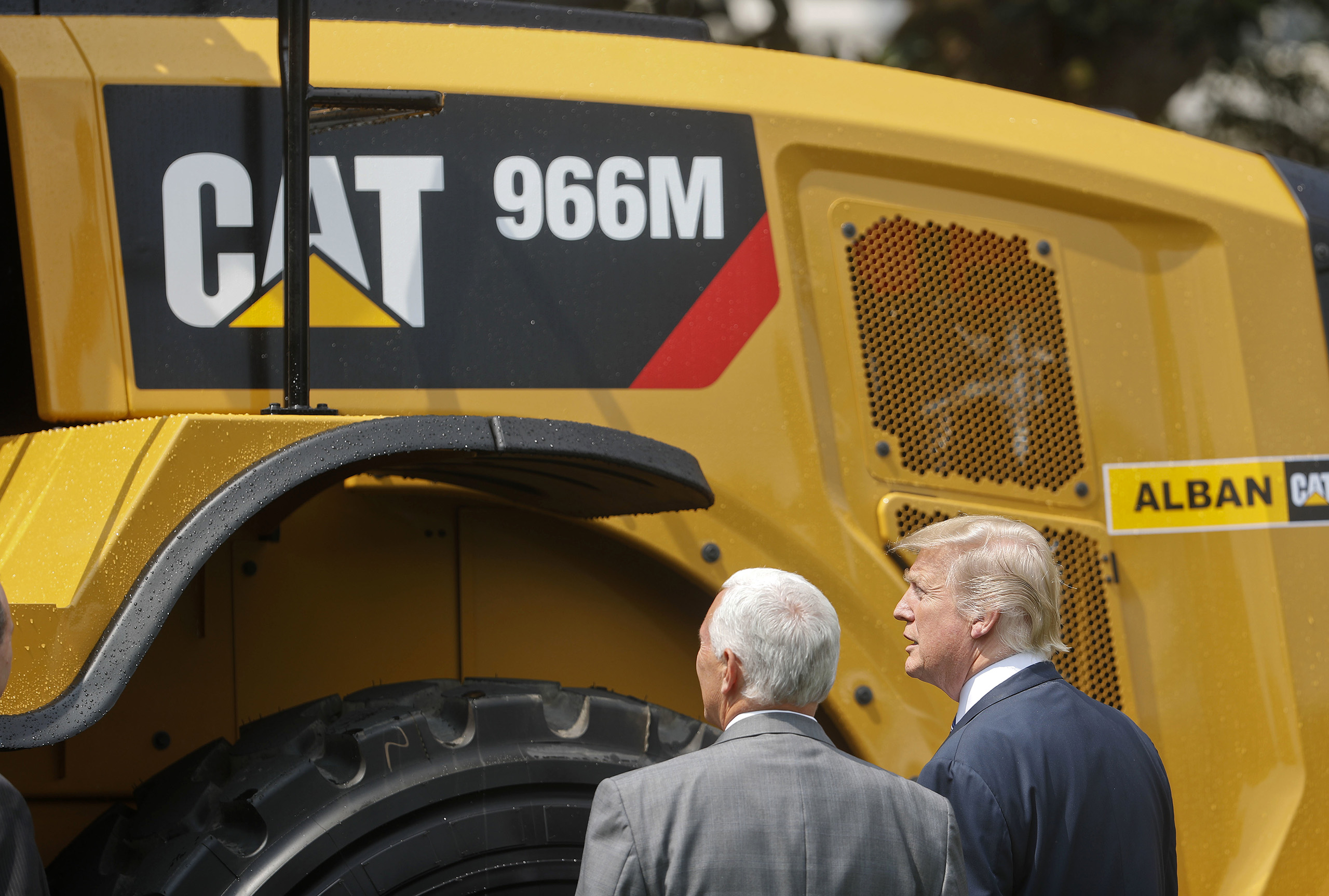 President Donald Trump and Vice President Mike Pence stop to looks at a Caterpillar truck, manufactured in Illinois, on the South Lawn of the White House in Washington, Monday, July 17, 2017, during a  Made in America,  product showcase featuring items created in each of the U.S. 50 states.