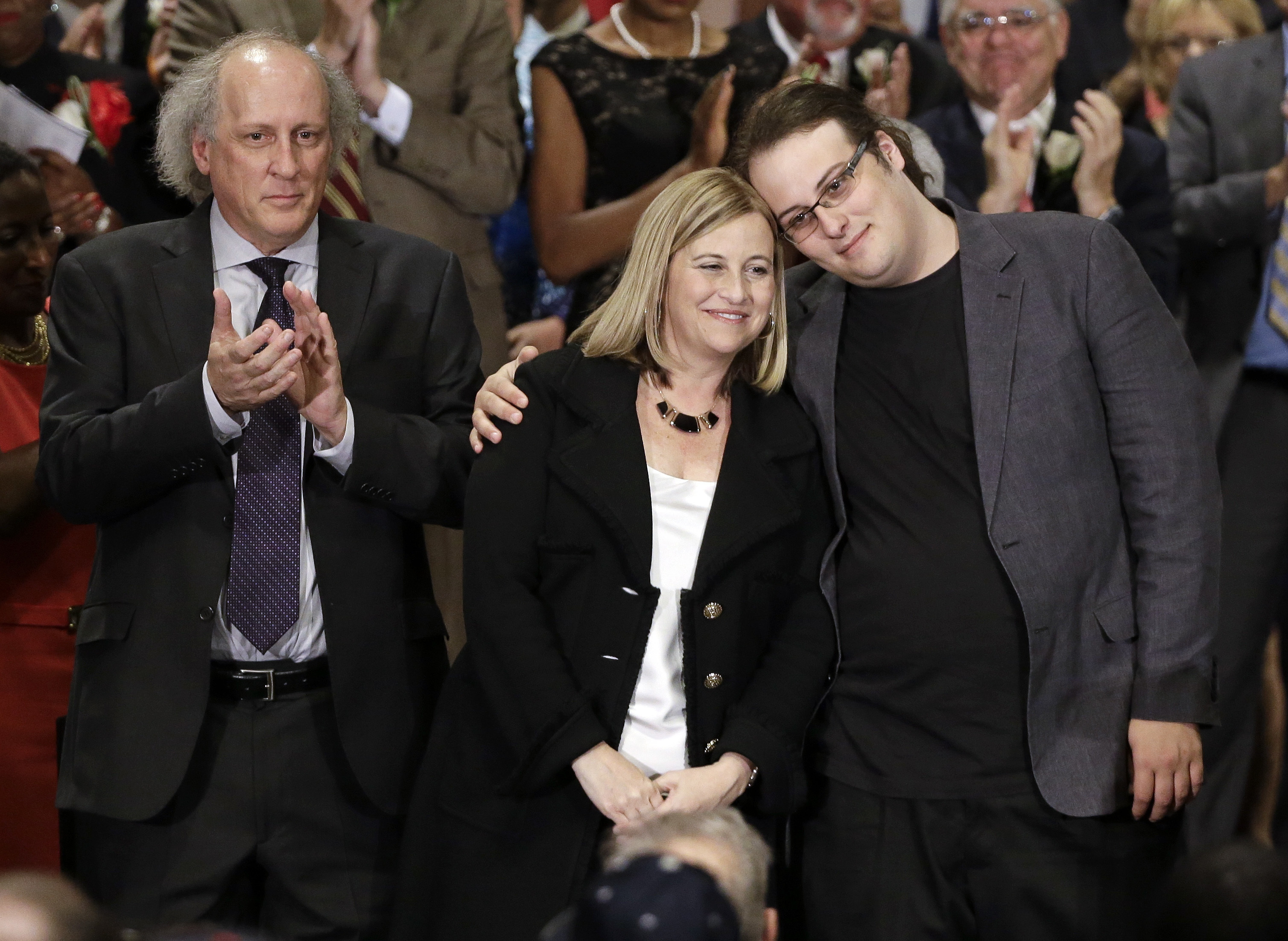 Nashville Mayor Megan Barry, center, is hugged by her son, Max, as her husband, Bruce, left, applauds after she was sworn into office in Nashville, Tenn., on Sept. 25, 2015 (Mark Humphrey—AP)