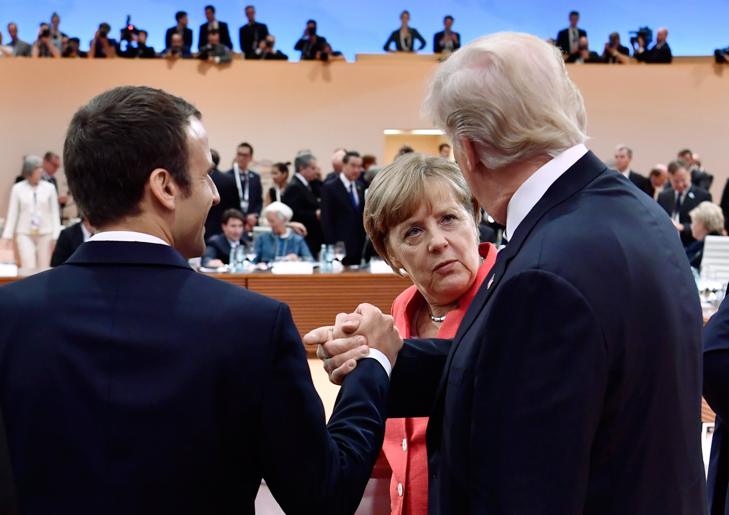 Macron, left, and Trump, right, chat with Merkel in Hamburg on July 7