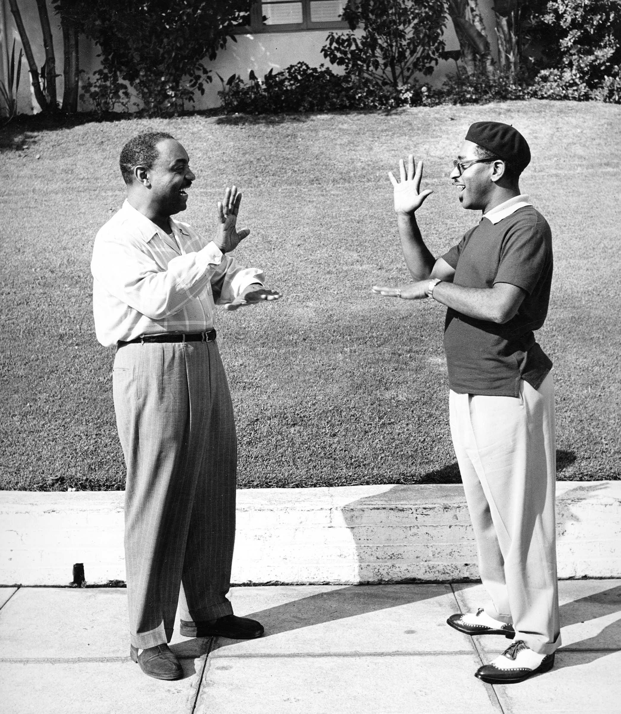 "Bebop" jazzman Dizzy Gillespie, showing his friend Benny Carter how to do a special handshake greeting, 1947.