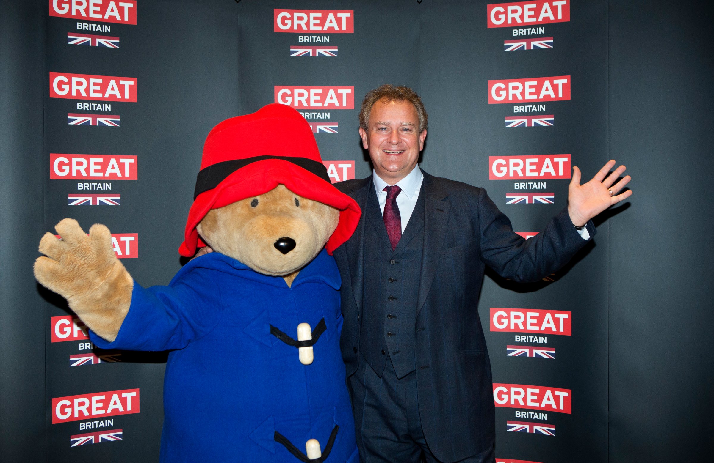 Actor Hugh Bonneville poses with a person dressed as Paddington Bear during the photo call for the film Paddington Bear at The British Embassy in Berlin, during the International Film Festival Berlinale, Feb. 7, 2014.