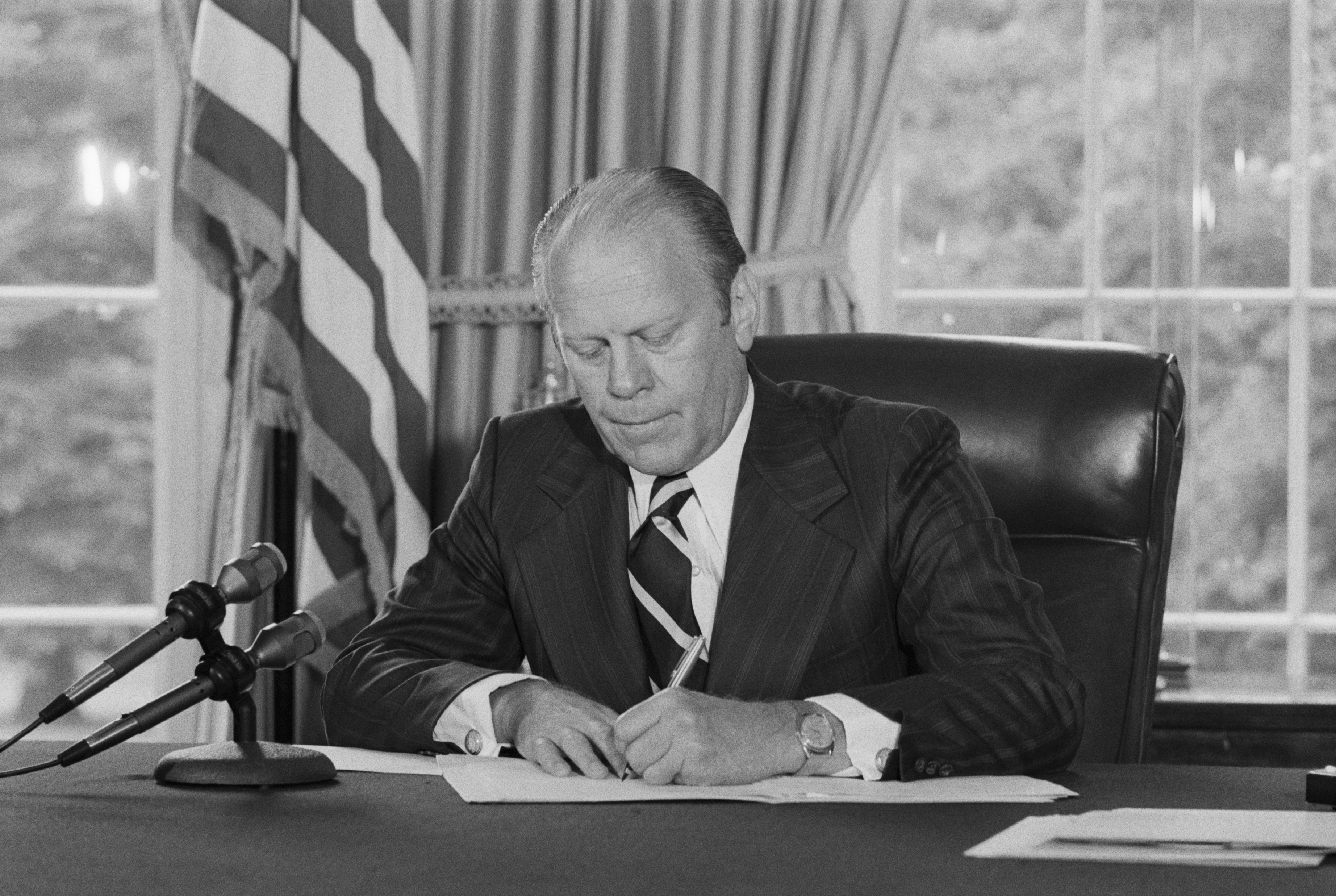 One month after Richard Nixon's resignation over the Watergate scandal, President Ford signs his pardon on Sep. 8, 1974. (Bettmann—Getty Images)