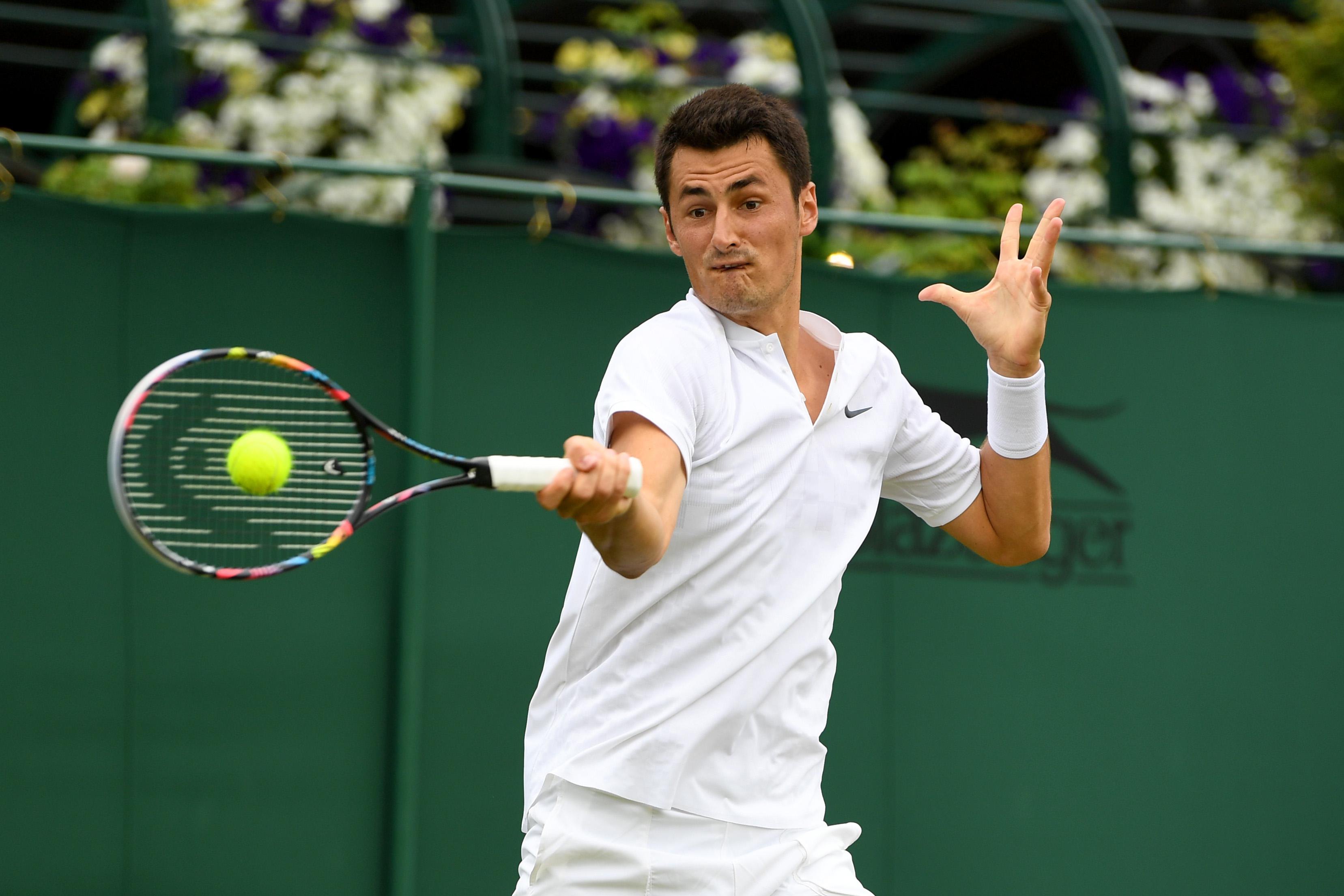 Bernard Tomic of Australia plays a forehand during the Gentlemen's Singles first round match against Mischa Zverev of Germany on day two of the Wimbledon Lawn Tennis Championships on July 4, 2017 in London, England. (David Ramos—Getty Images)