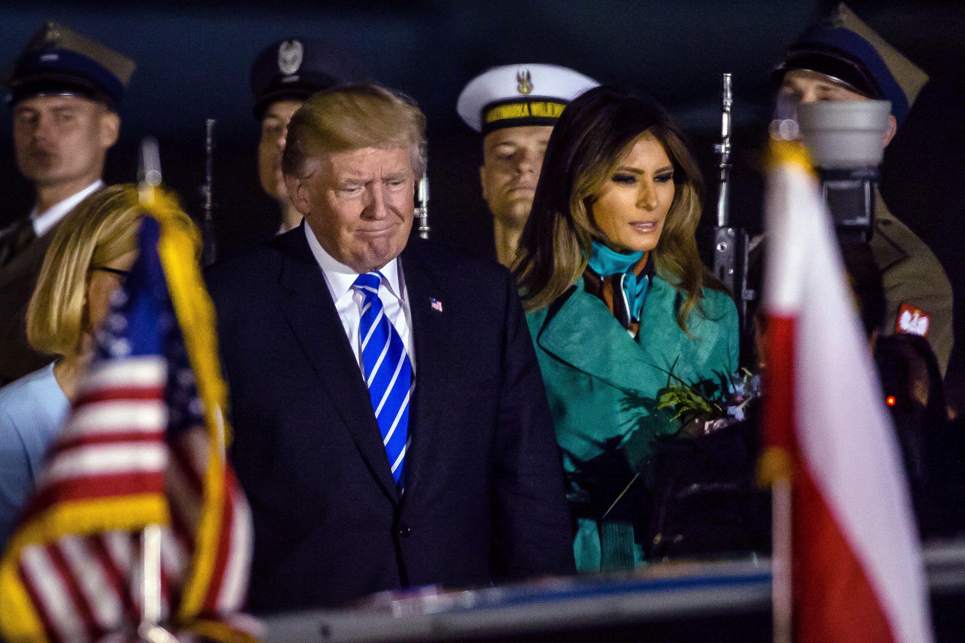 US President Donald Trump (L) and US First Lady Melania Trump (R) react after stepping off Air Force One upon their arrival at Chopin Airport in Warsaw,on July 5, 2017 (WOJTEK RADWANSK—AFP/Getty Images)