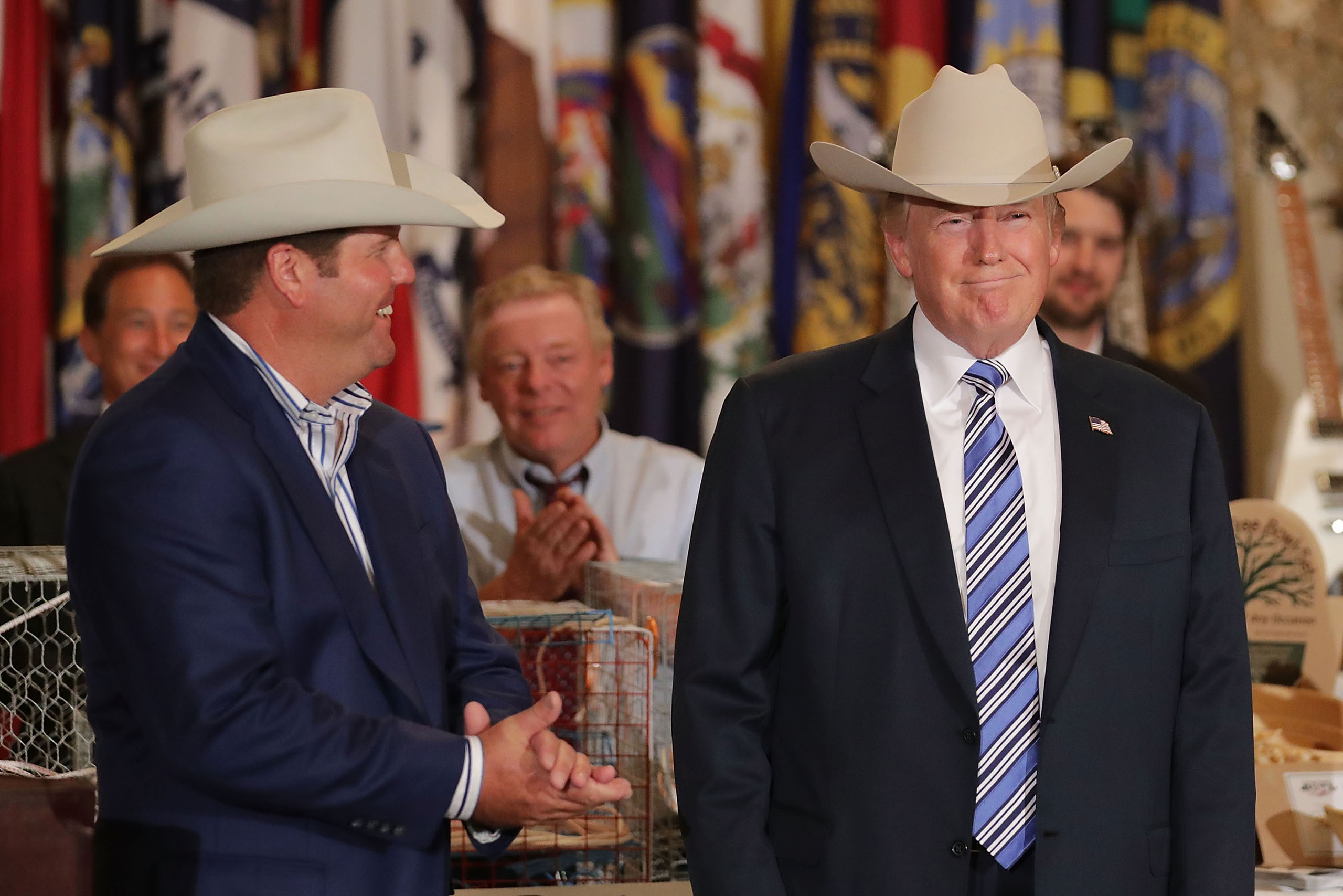 U.S. President Donald Trump wears a Stetson cowboy hat given to him by Dustin Noblitt (L) while touring a Made in America product showcase in the East Room of the White House July 17, 2017 in Washington, DC.