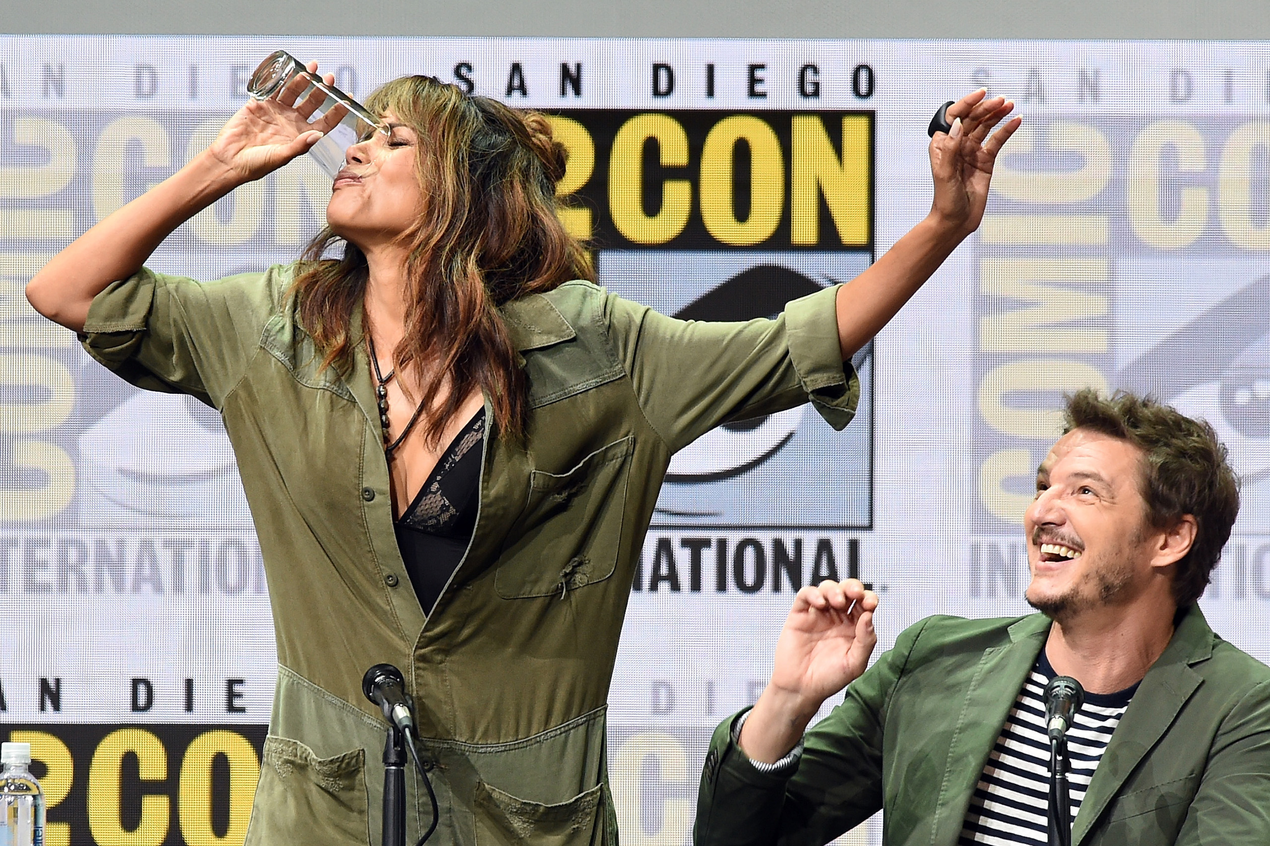 Actor Halle Berry takes a drink onstage while actor Pedro Pascal looks on at the 20th Century FOX panel during Comic-Con International 2017 at San Diego Convention Center on July 20, 2017. (Kevin Winter—Getty Images)