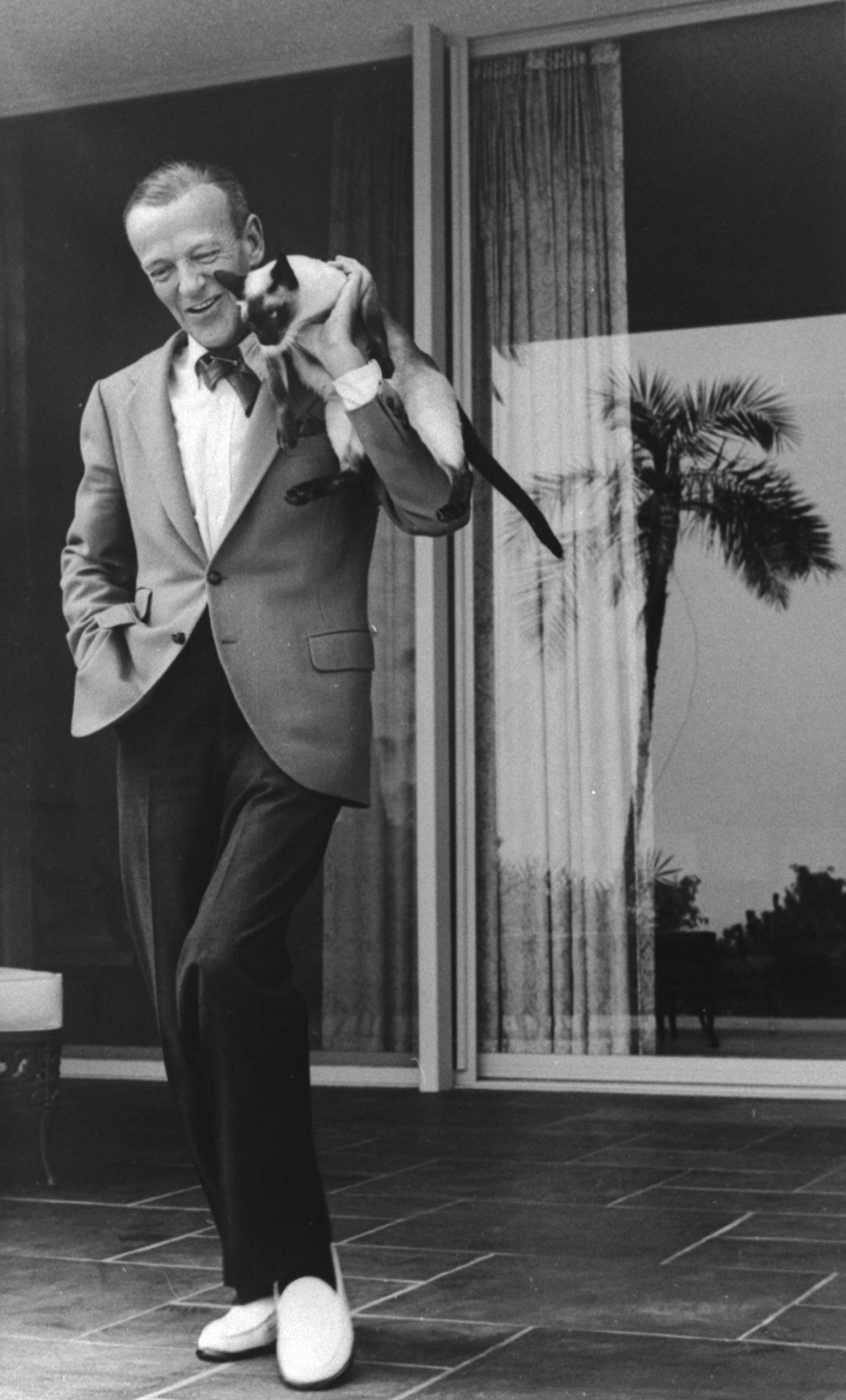 Fred Astaire dancing with his Siamese cat on his shoulder, 1962.