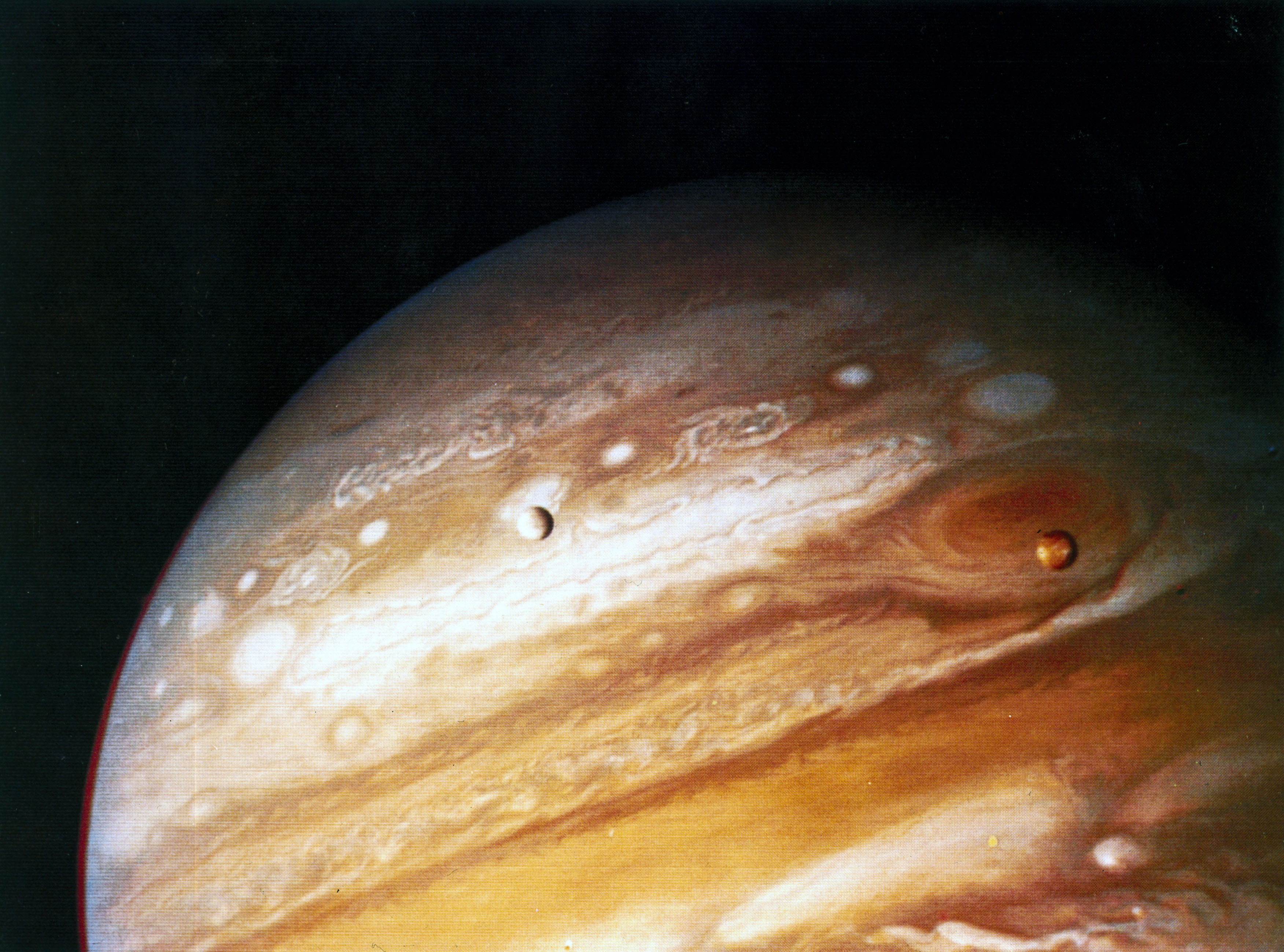 The planet Jupiter, showing two of its moons and the Great Red Spot, 1979.