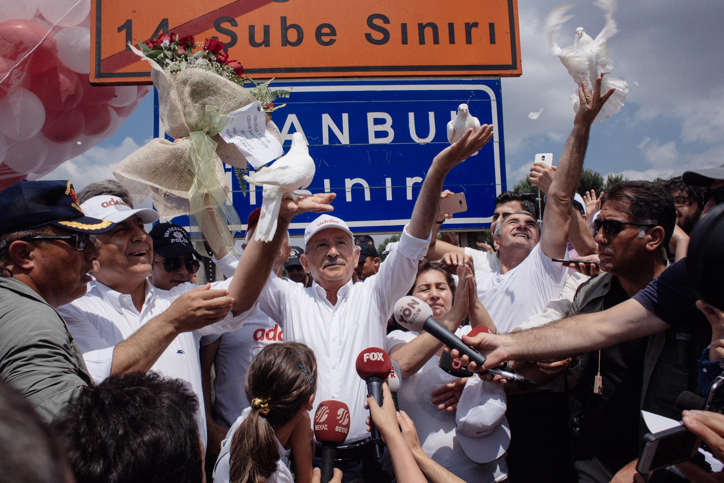 TURKEY. Istanbul. 2017. The head of Turkey's secularist Republican People's Party (CHP), Kemal Kilicdaroglu enters to Istanbul with thousands of supporters after the 23 days of Justice march. He stands near the Istanbul sign and frees doves at the entrance of Istanbul