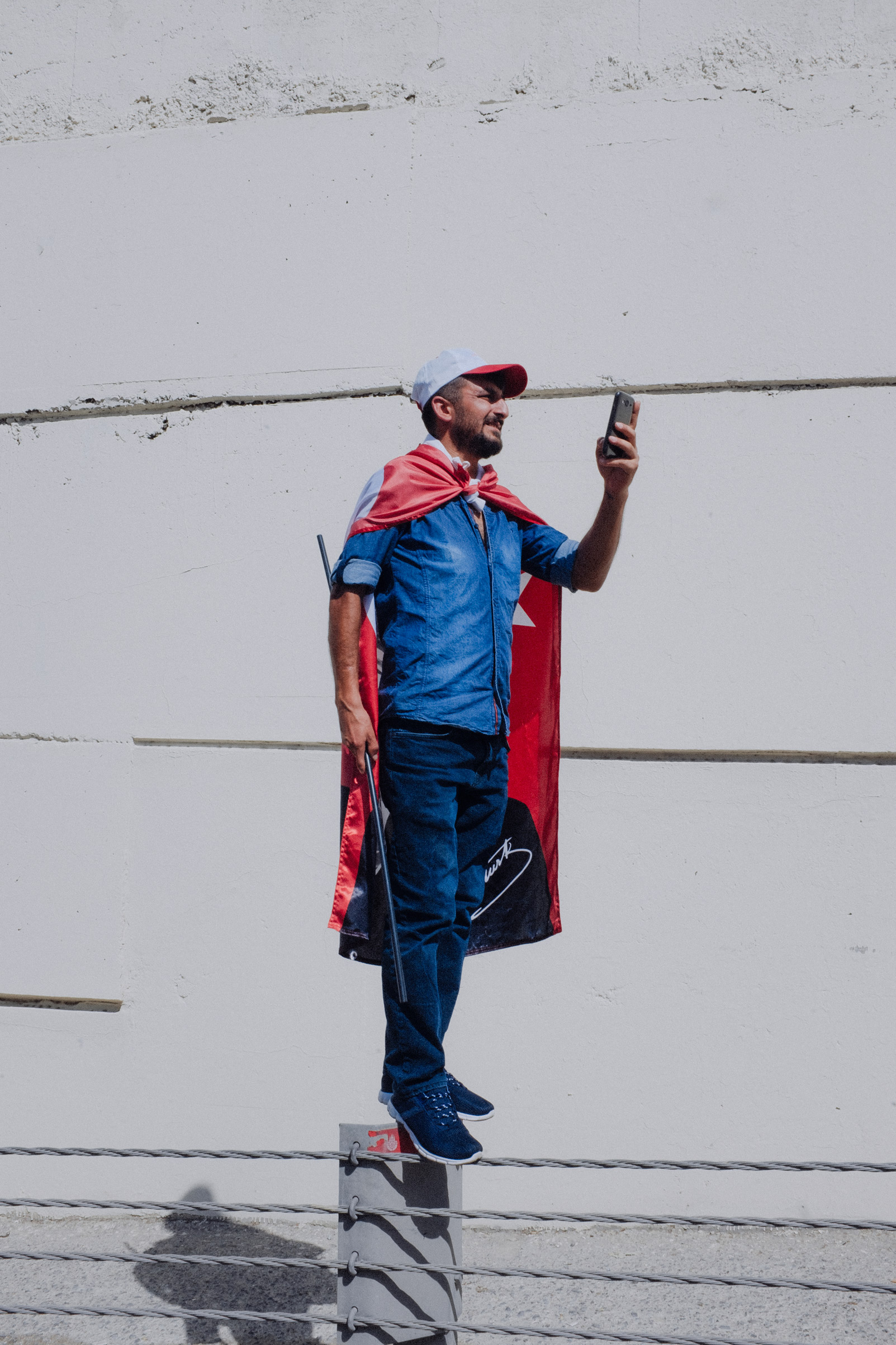 TURKEY. Istanbul. A man with a Turkish flag on, records the Justice march with his mobile phone near the highway.
