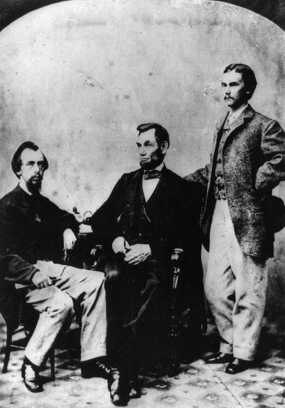 President Arbraham Lincoln, center, with his secretaries in 1863. John Hay is seen standing at right. (Alexander Gardner—UIG via Getty Images)