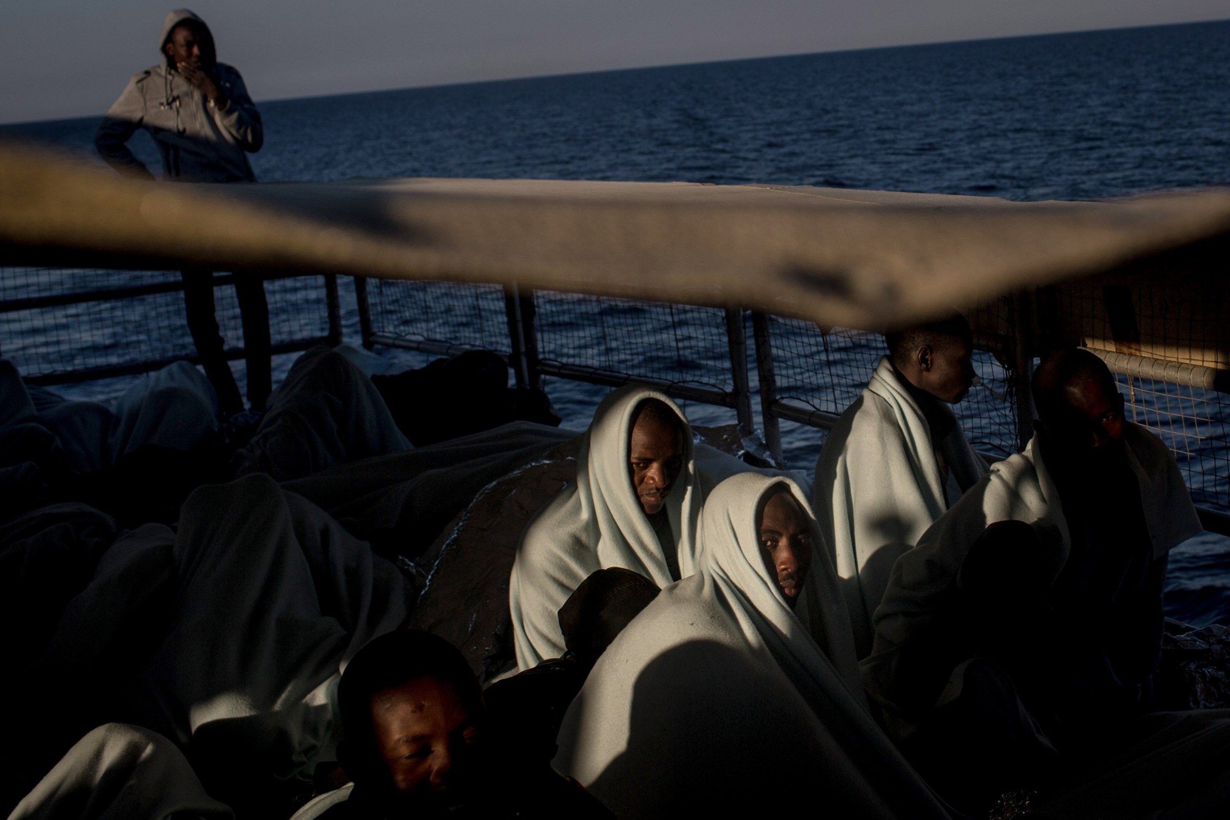 Refugees and migrants look out at Italy as they arrive on a Migrant Offshore Aid Station (MOAS) vessel to Reggio Calabria, Italy, on June 12, 2017.