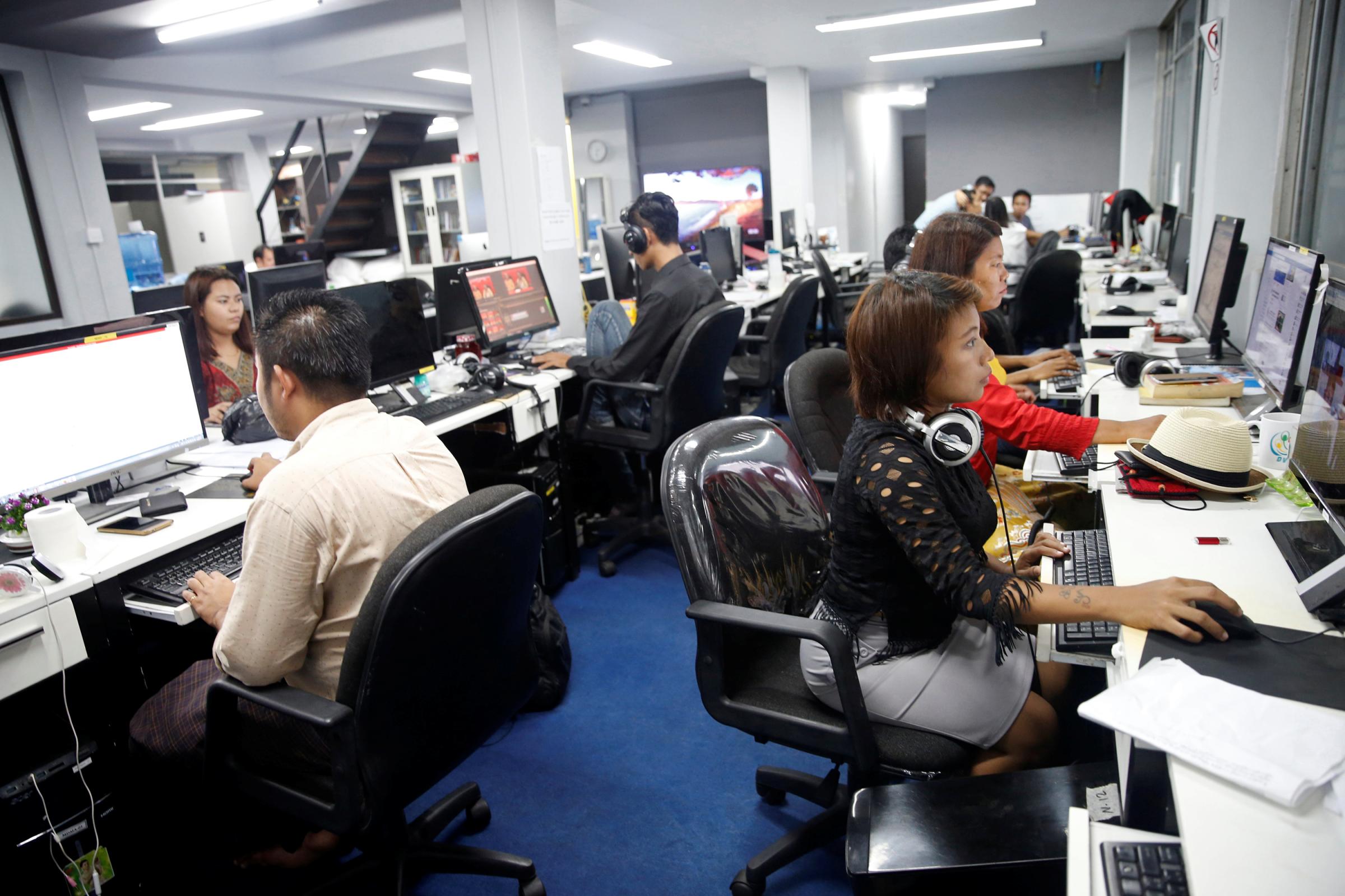 Reporters work in the DVB news room in Yangon