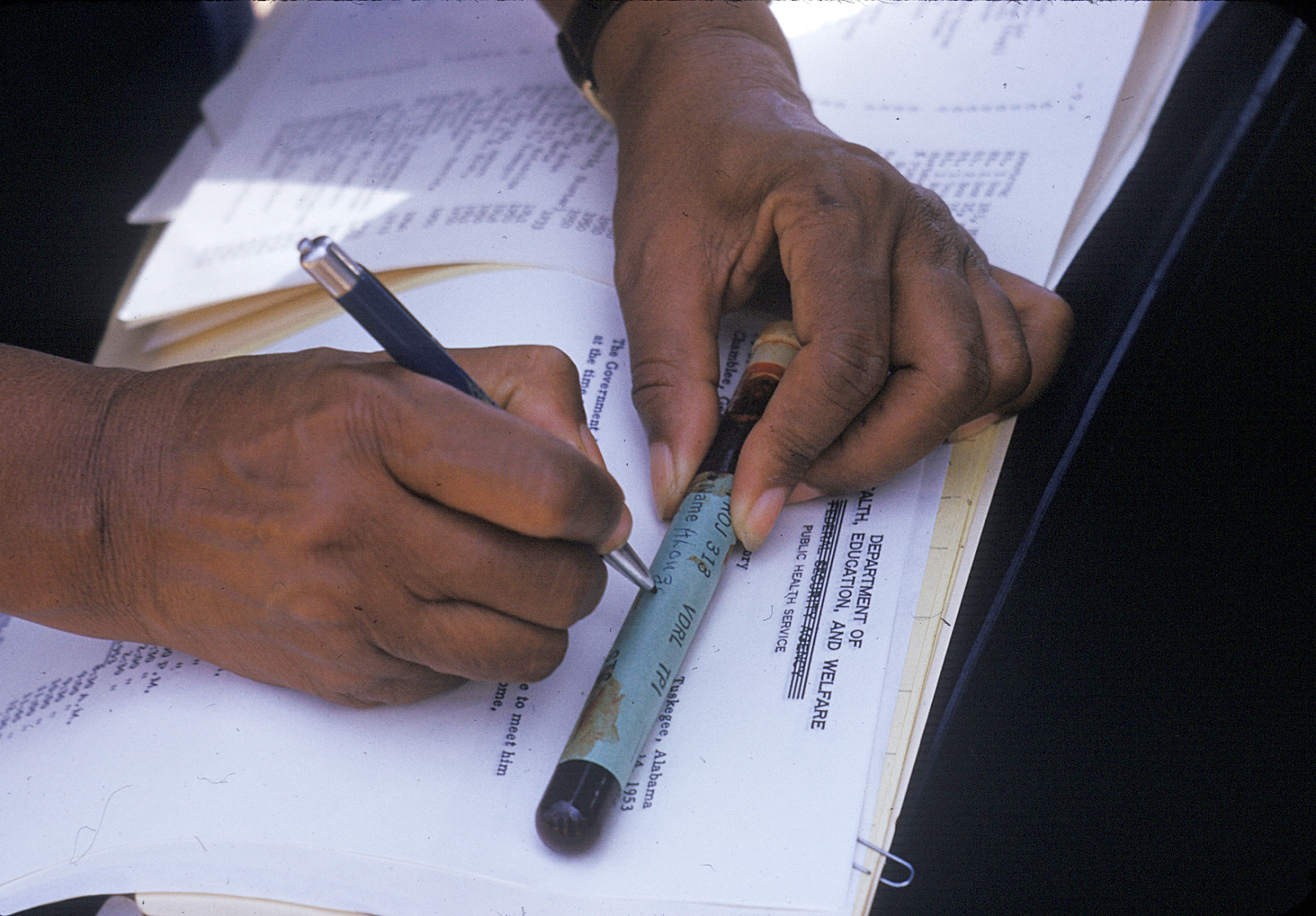 In this 1950's photo released by the National Archives, a nurse writes on a vial of blood taken from a participant in a syphilis study in Tuskegee, Ala. (National Archives/AP)