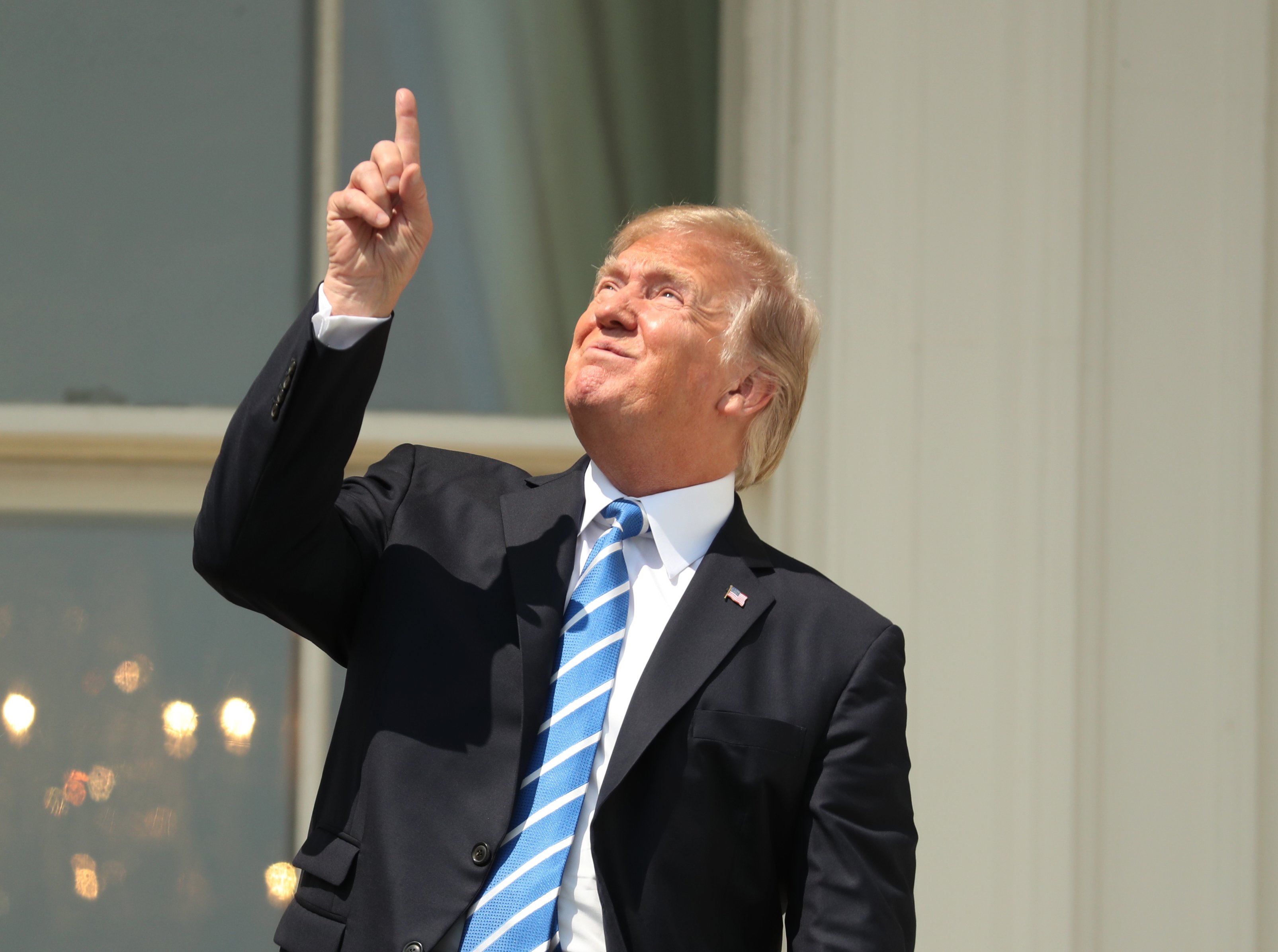 President Donald Trump points skyward before donning protective glasses to view the solar eclipse, Monday, Aug. 21, 2017, at the White House in Washington . (Andrew Harnik—AP)