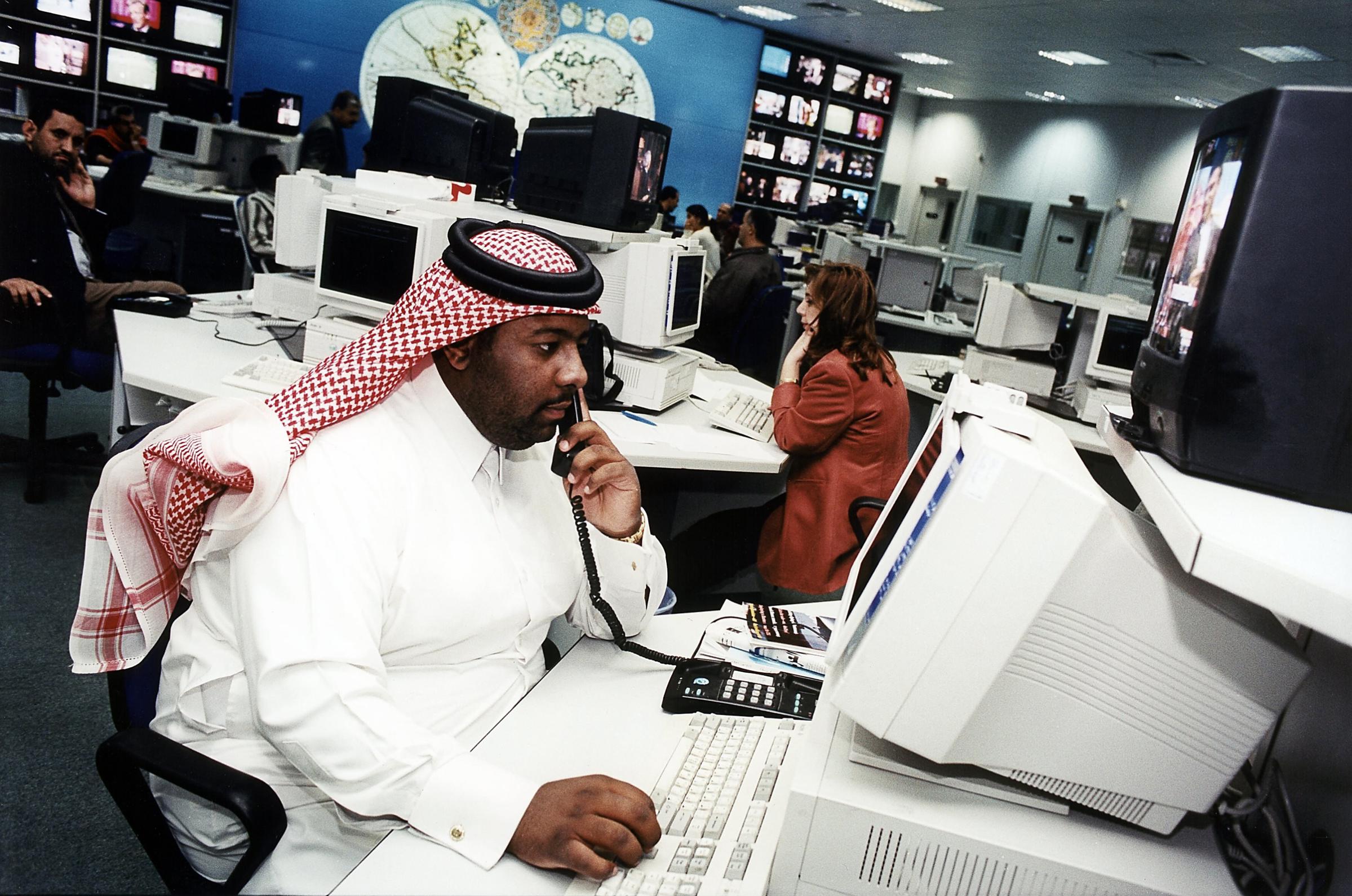 A journalist works in the Doha newsroom in April 2001.