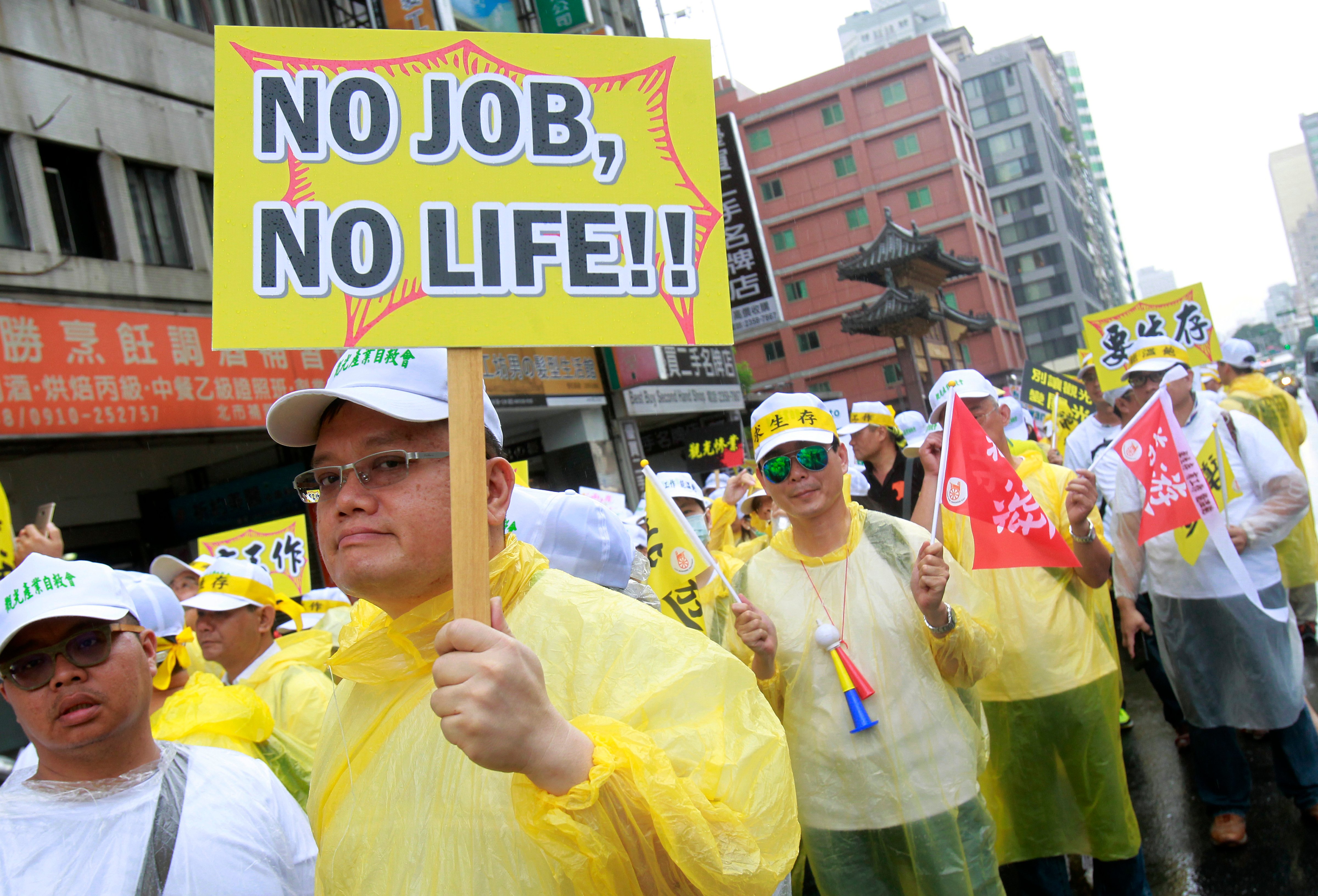 A tourism-related business worker holds a slogan reading 