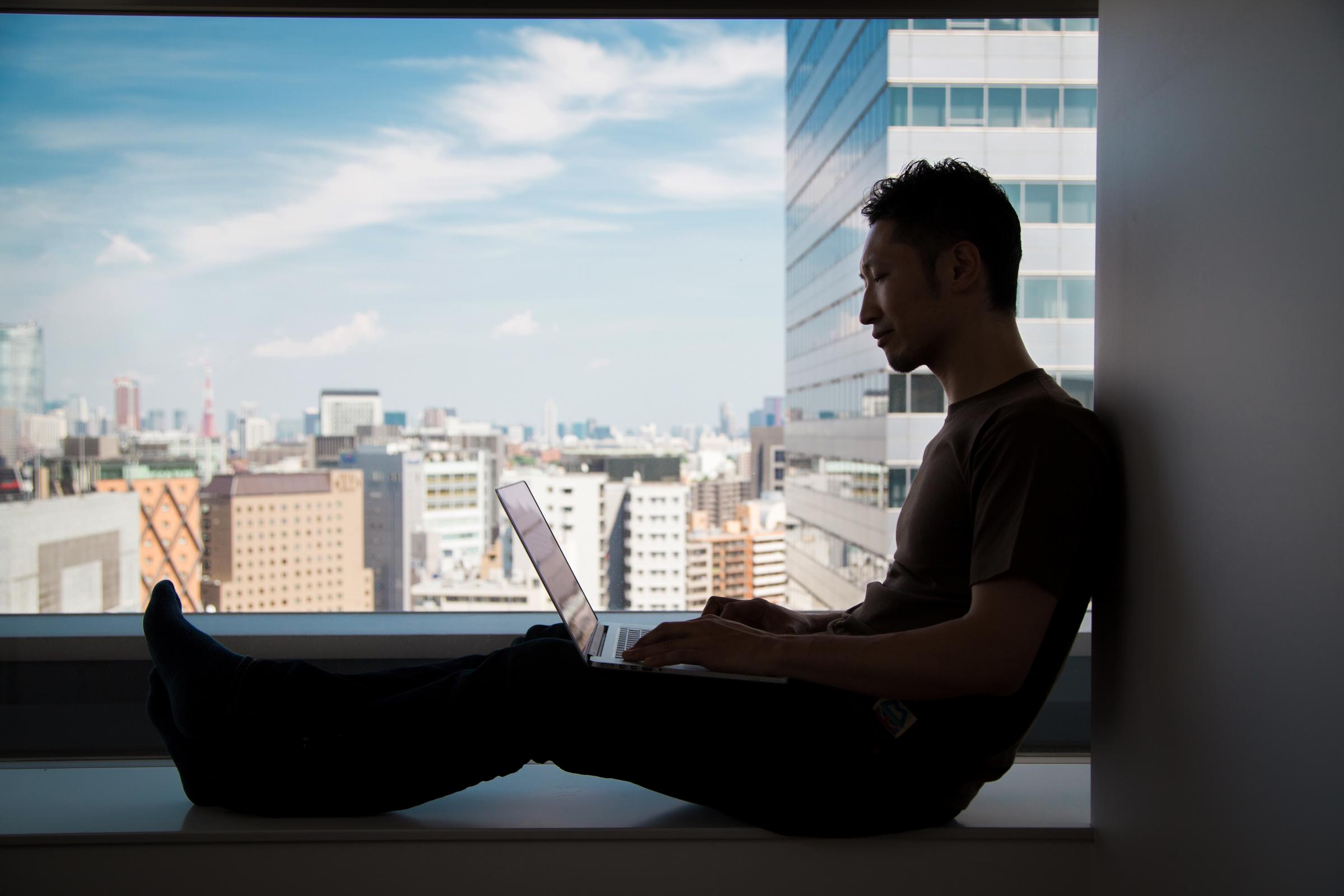 Silhouette of a man using computer