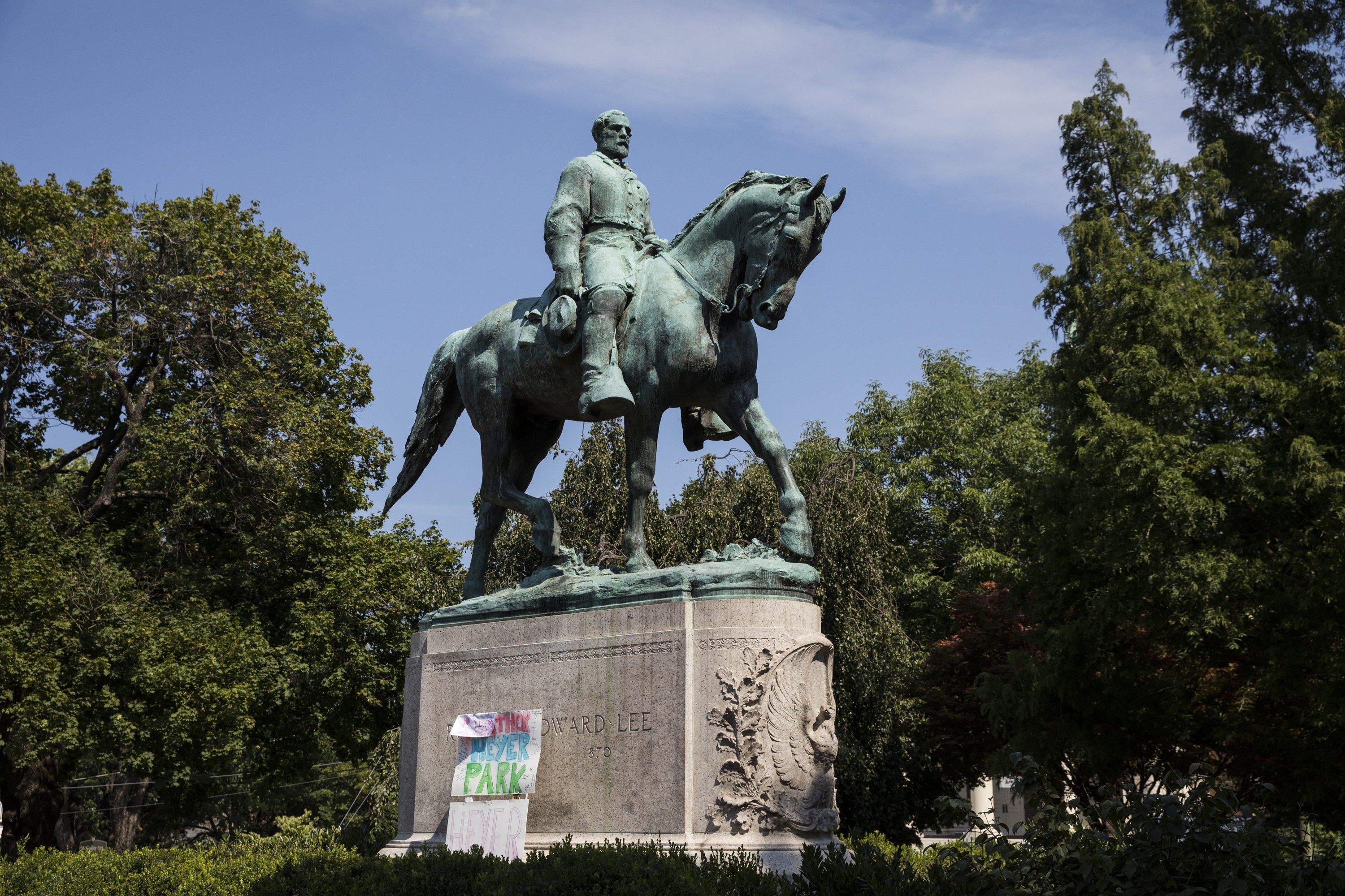 Signs calling for renaming Lee Park to Heyer Park, the site where white supremacists and Nazis gathered last Saturday, lay at the base of the Robert E. Lee statue after Heather Heyer was murdered, in Charlottesville, Virginia, on Aug. 16, 2017. (Samuel Corum—Anadolu Agency/Getty Images)