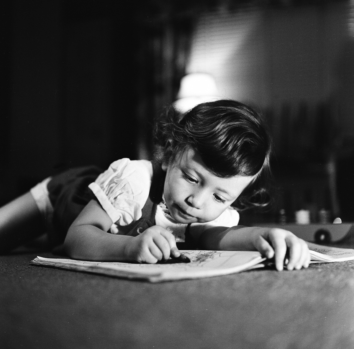 View of a young girl, filling in sketches in a coloring book, with crayon in hand, New York, 1948. (Rae Russel—Getty Images)