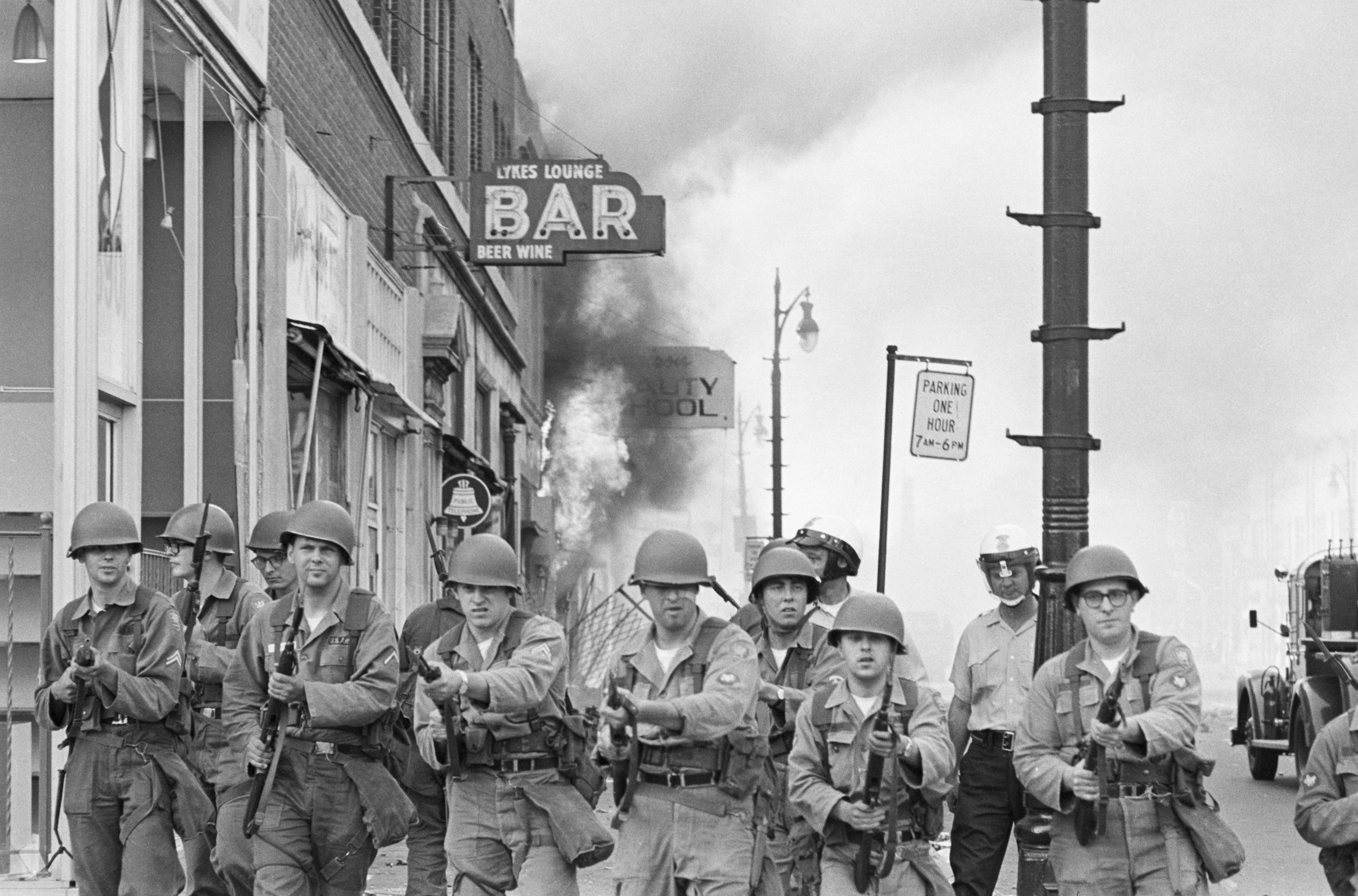 Michigan National Guardsmen push rioting citizens back from a burning Detroit building with fixed bayonets in July of 1967. (Bettmann / Getty Images)
