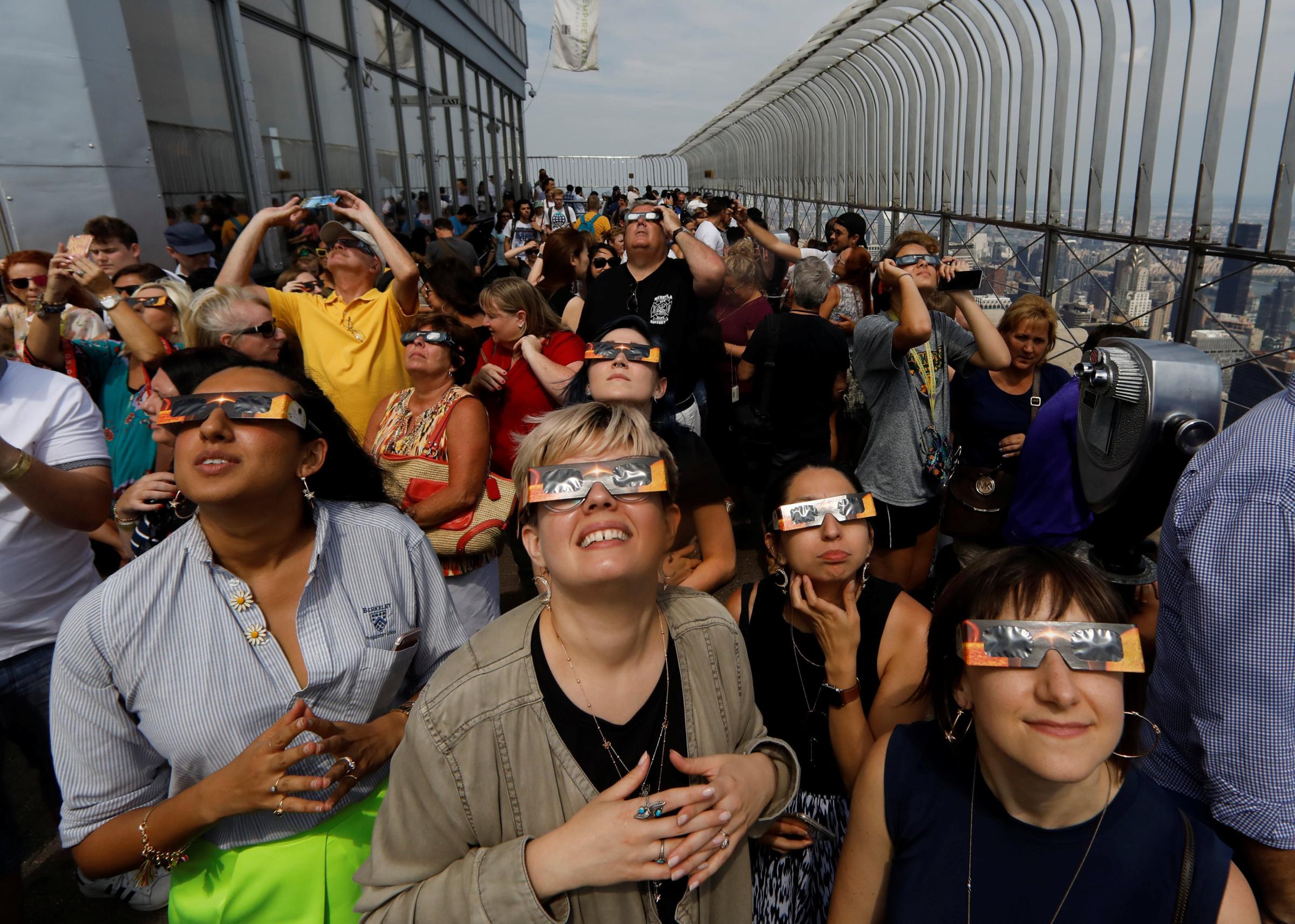 People watch the solar eclipse from the observation deck of The Empire State Building in New York