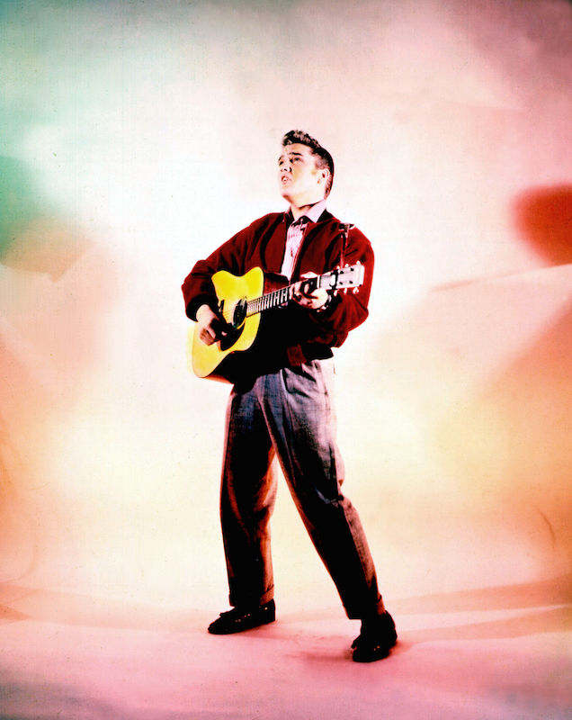 Elvis Presley poses for a portrait while playing his acoustic guitar in 1956 (Michael Ochs Archives / Getty Images)