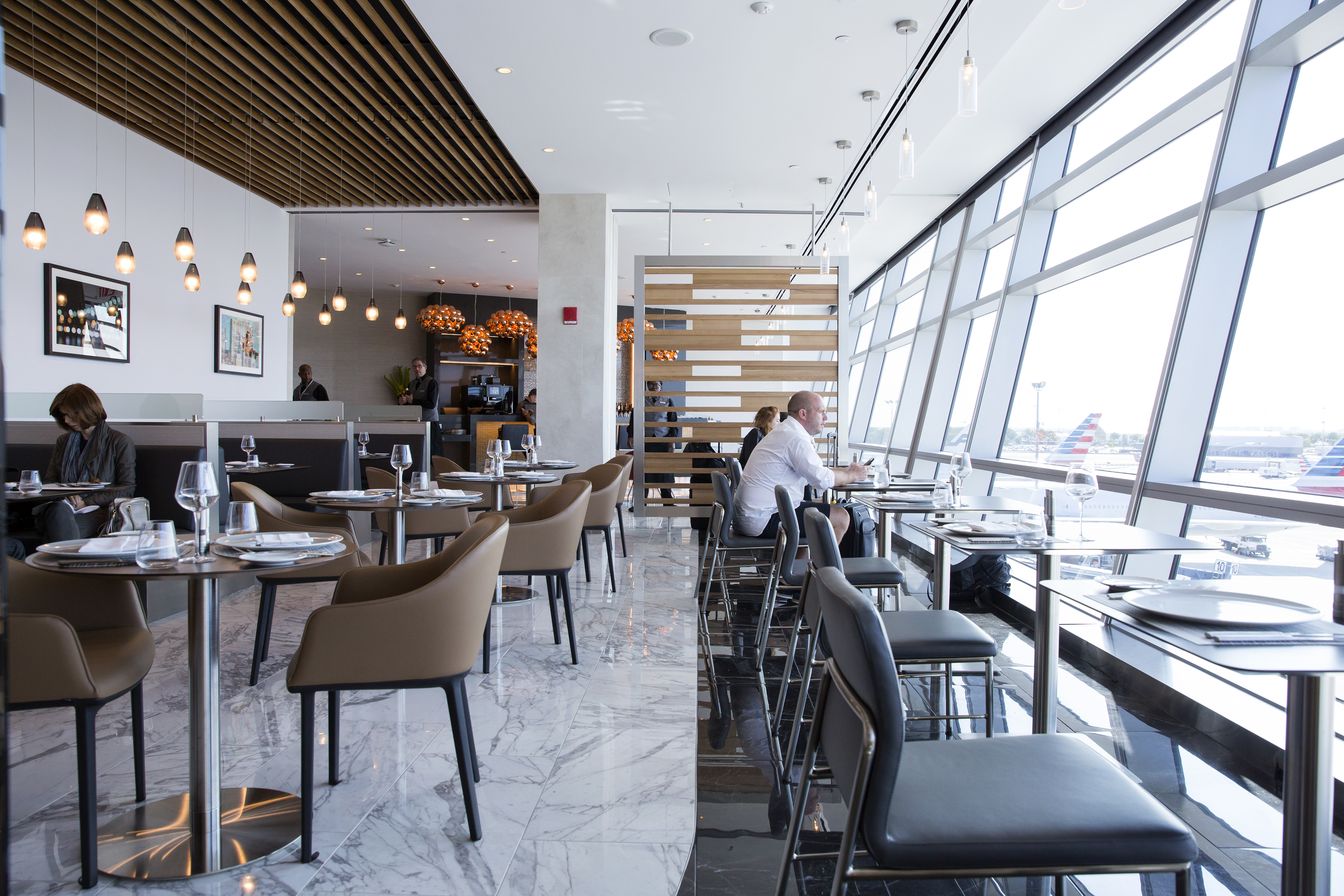 Customers sit inside the American Airlines Group Inc. Flagship First Dining room at John F. Kennedy International Airport (JFK) in New York, U.S., on Thursday, June 15, 2017. American Airlines opened its first full service restaurant-style dining room for transcontinental first class travelers, keeping the amenity highly exclusive focusing on premium customers. Photographer: Caitlin Ochs/Bloomberg via Getty Images (Bloomberg&mdash;Bloomberg via Getty Images)