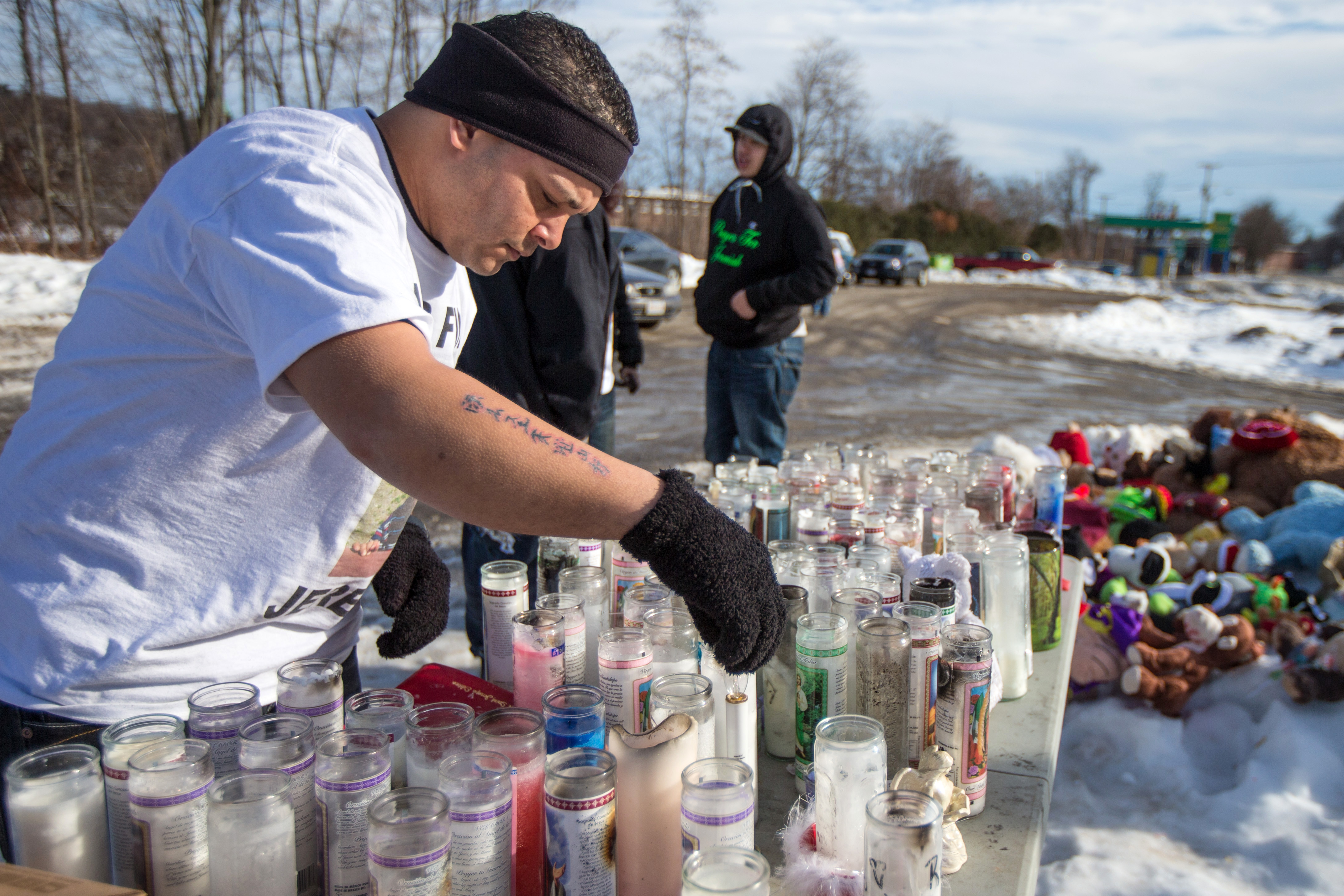 Jose Oliver visited a memorial of toys and candles set up in front of 276 Kimball Street in Fitchburg after the disappearance of his son, Jeremiah Oliver. (Photograph by Aram Boghosian—Getty/The Boston Globe)