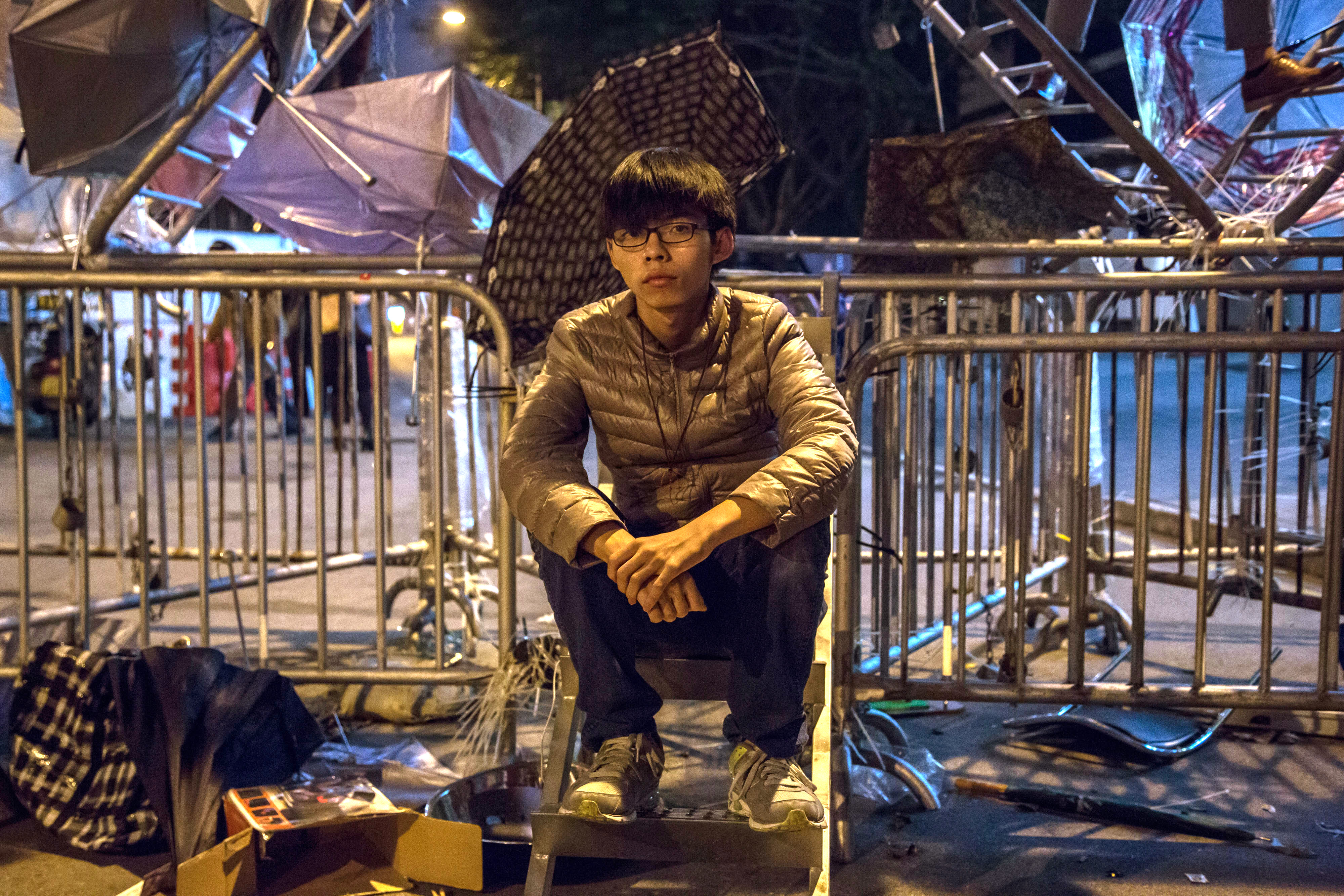 Joshua Wong, then 17 and leader of the pro-democracy group Scholarism, sits on steps alongside metal security barriers outside the Central Government Offices in the Admiralty district of Hong Kong, China, on Wednesday, Dec. 10, 2014. (Lam Yik Fei/Bloomberg via Getty Images)