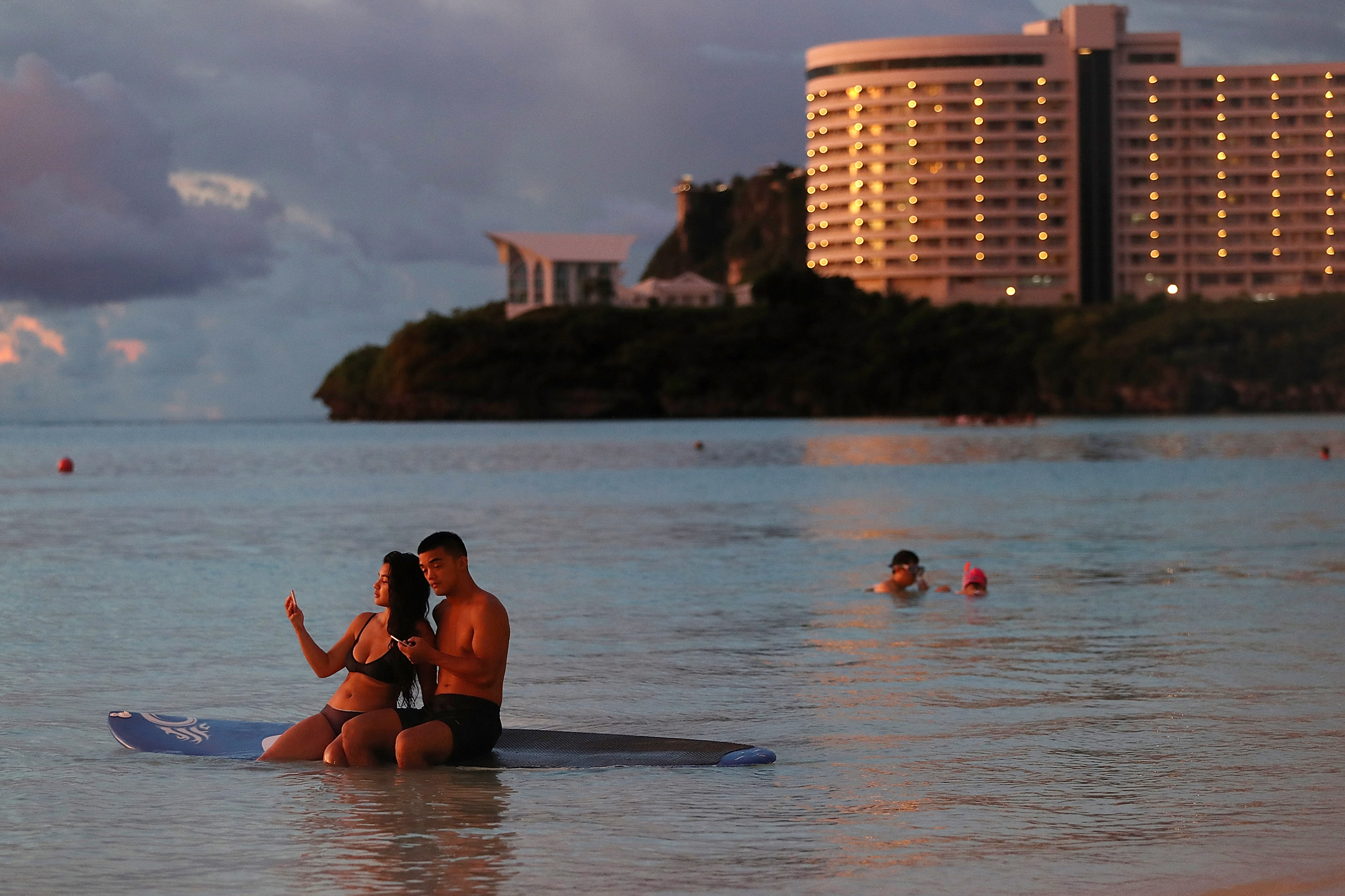 A couple sits on a paddle board at Tumon Bay on August 16, 2017 in Tamuning, Guam. The American territory remains on high alert as a showdown between the U.S. and North Korea continues. (Justin Sullivan—Getty Images)