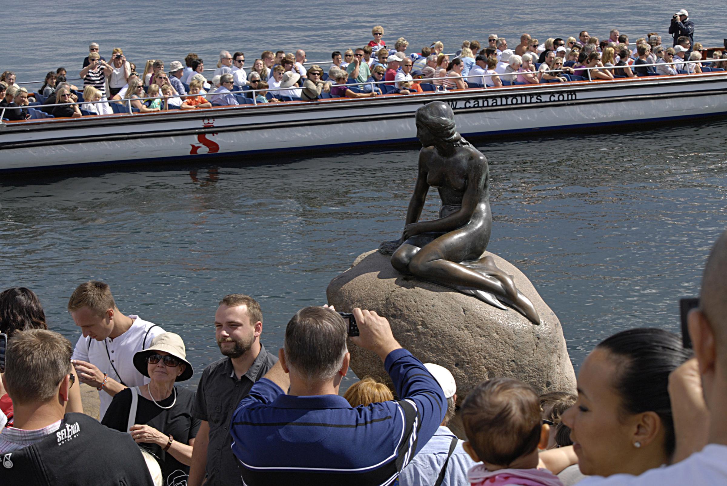 Tourists are photographing little mermaid