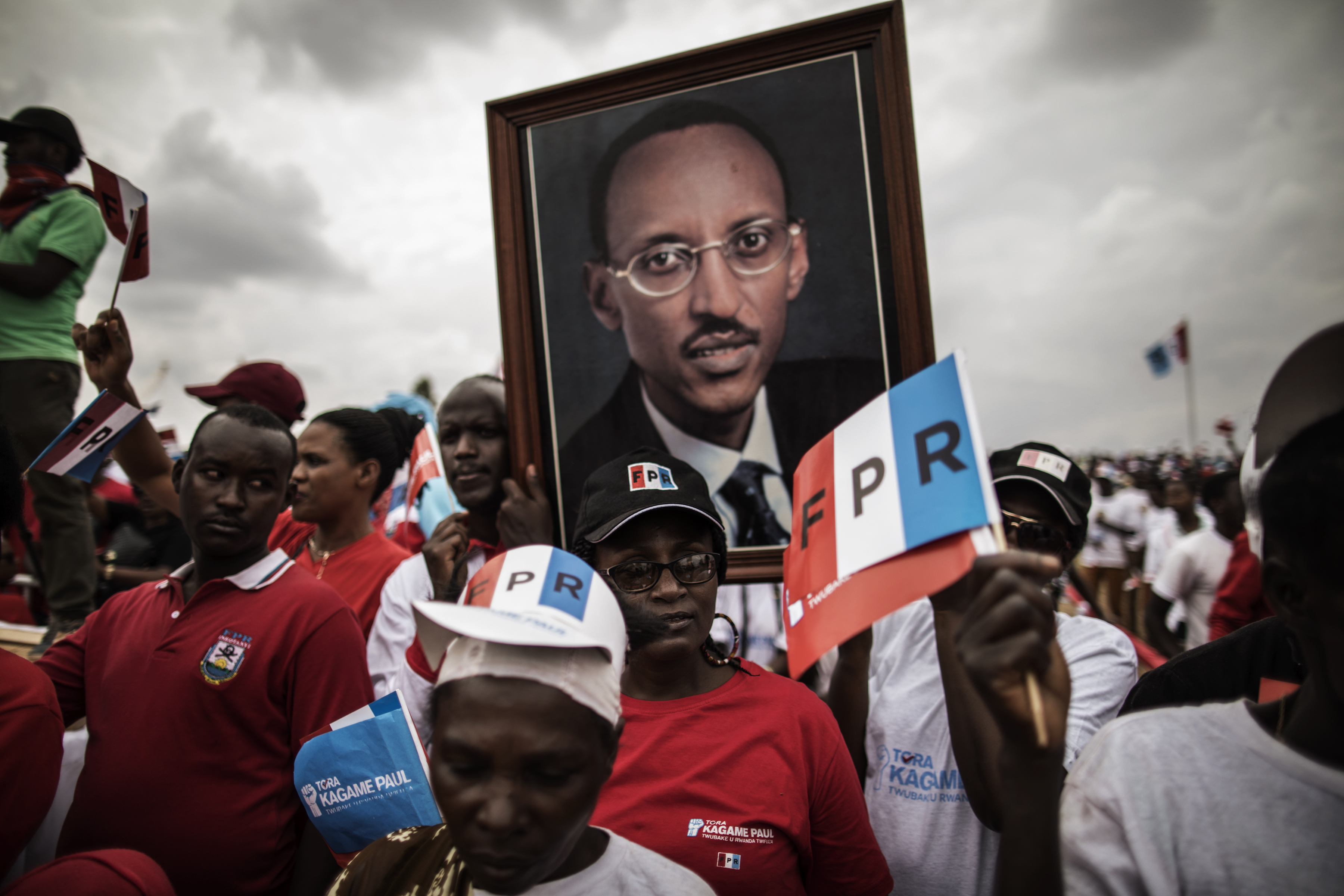 Supporters of incumbent President Paul Kagame carry a large photograph of him during the campaign's closing rally in Kigali, on August 2, 2017.