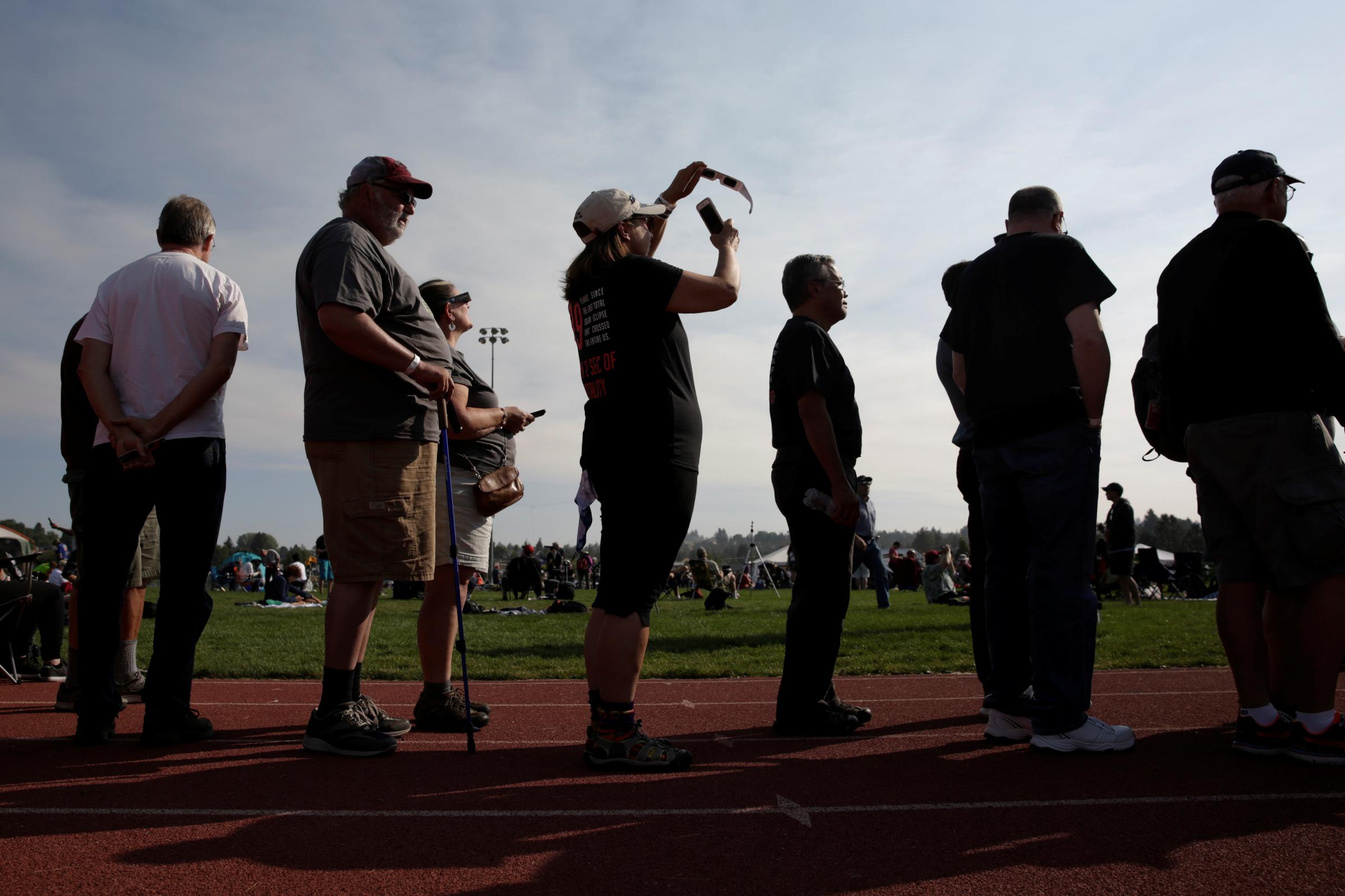 People watch the solar eclipse during the Lowell Observatory Solar Eclipse Experience at Madras High School in Madras, Oregon