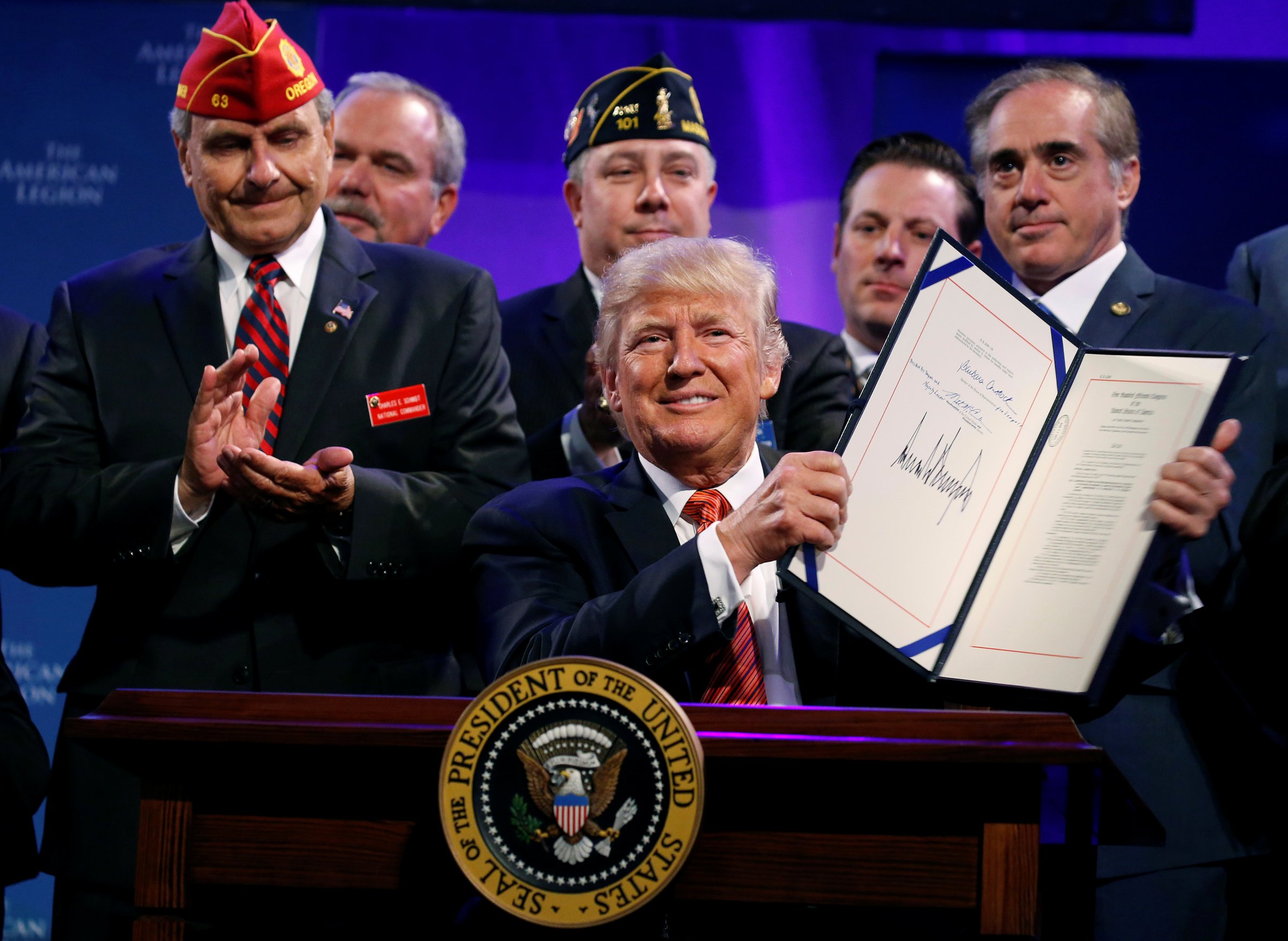 U.S. President Donald Trump holds up the Veterans Appeals Improvement and Modernization Act after signing it in Reno, Nevada