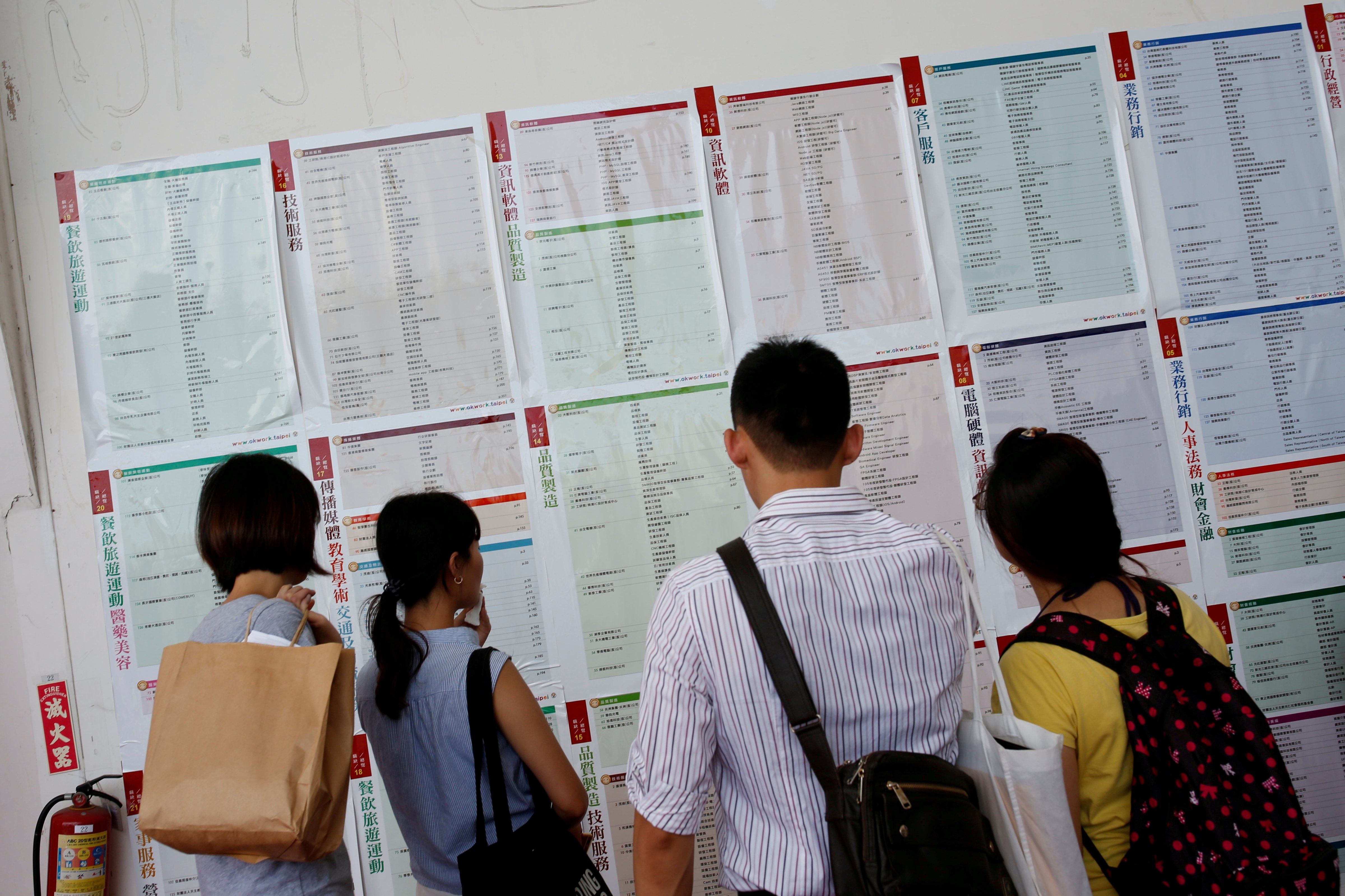Job seekers look at job information at an employment fair in Taipei, Taiwan on May 28, 2016. (Tyrone Siu—REUTERS)