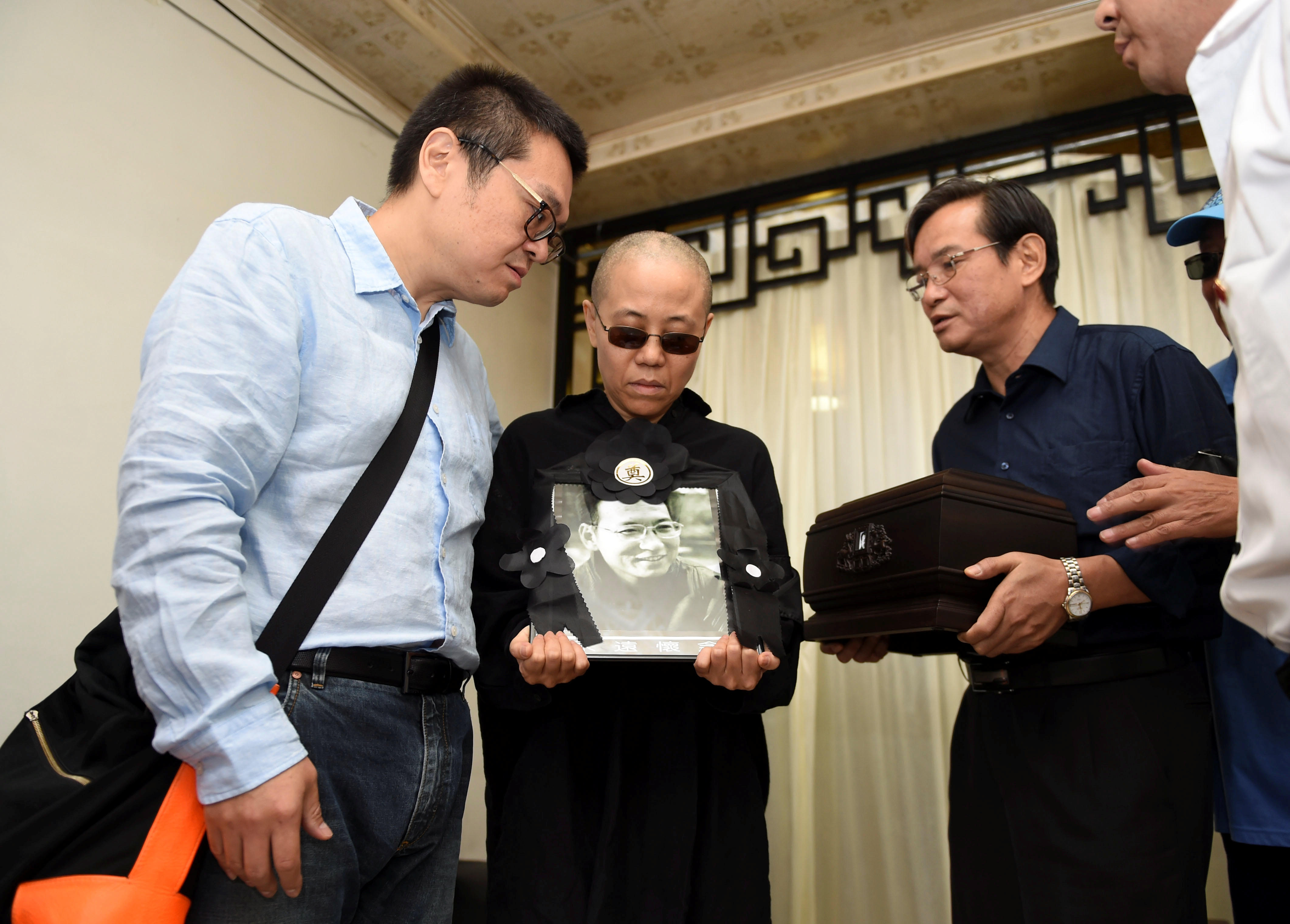 Liu Xia holds a picture of her husband, deceased Chinese Nobel laureate Liu Xiaobo, during his funeral in Shenyang, China on July 15, 2017. (Shenyang Municipal Information Office—Handout/Reuters)