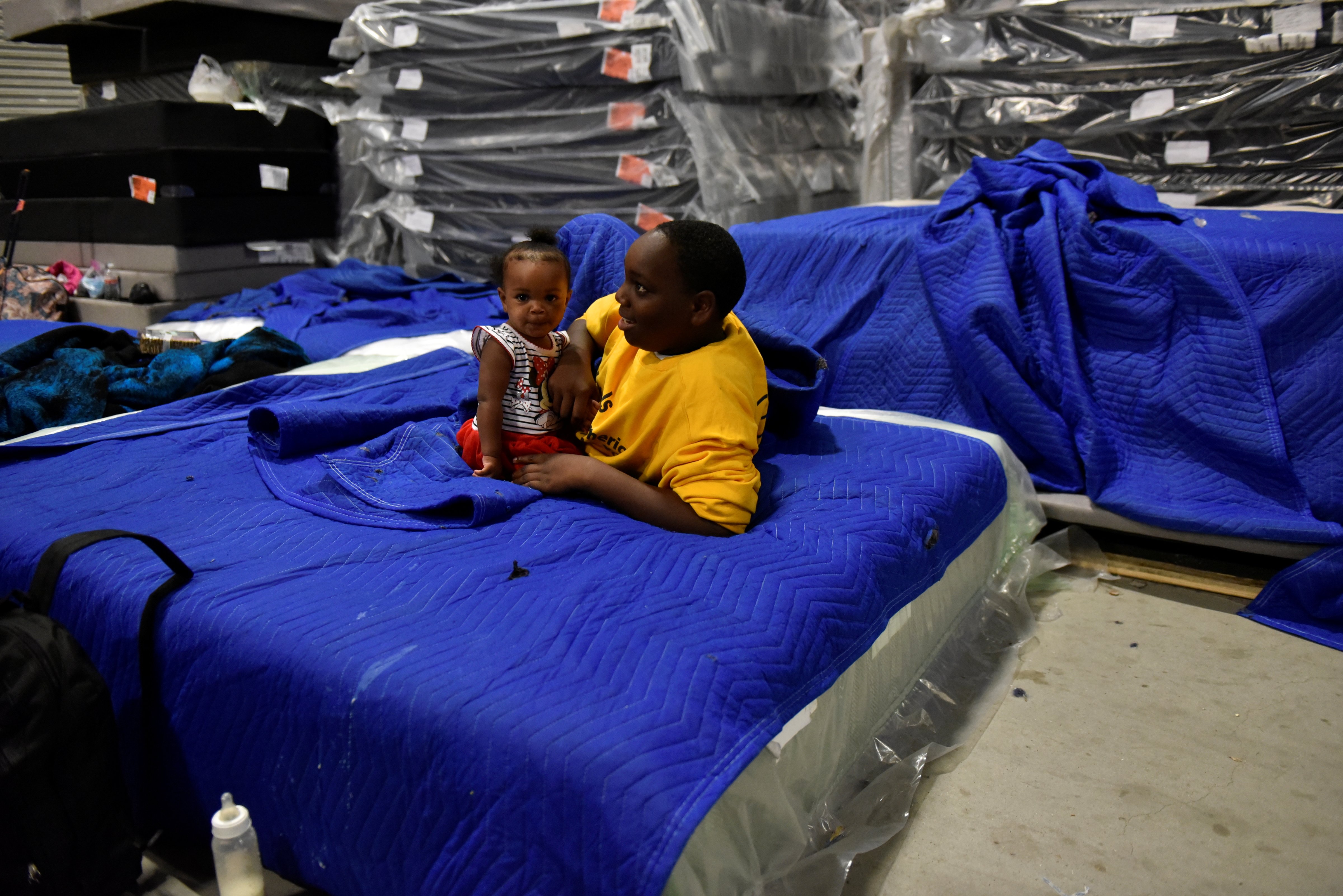 Jakobe Thomas plays with his sister Journey Thomas, 1, in the warehouse at Gallery Furniture where they have been staying after evacuating their flooded home over the weekend, in Houston, Texas, U.S., August 29, 2017. REUTERS/Nick Oxford - RTX3DVUW (Nick Oxford—REUTERS)