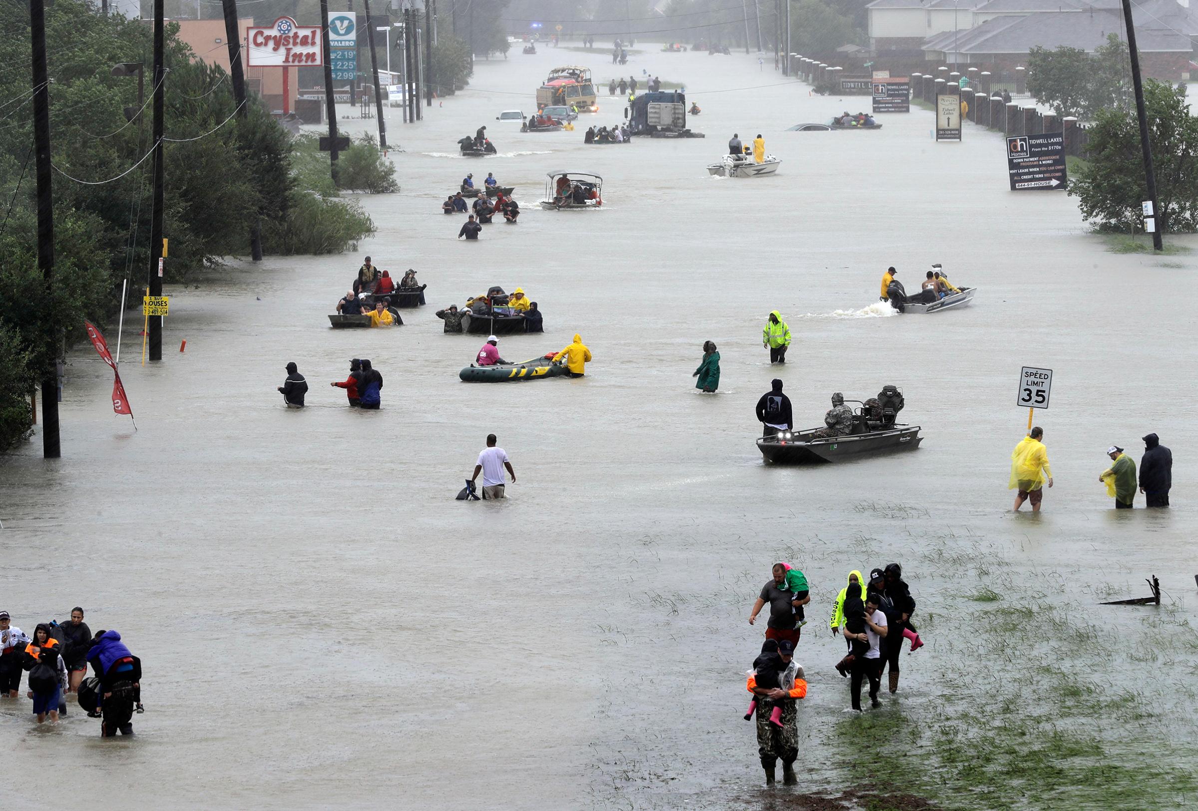 Rescue boats fill a flooded street as flood victims are evacuated floodwaters from Tropical Storm Harvey rise, Aug. 28, 2017, in Houston.