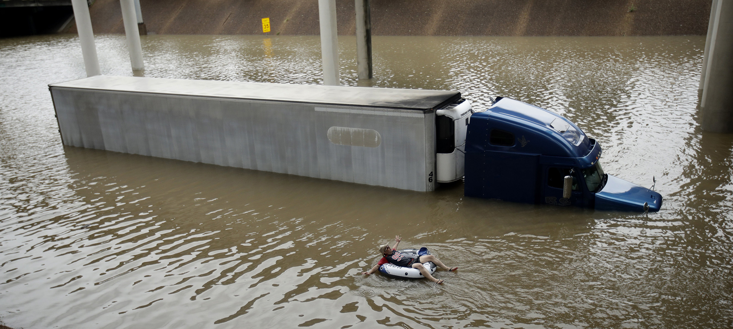 After helping the driver of the submerged truck get to safety, a man floats on the freeway flooded by Tropical Storm Harvey on Aug. 27, 2017, near downtown Houston.