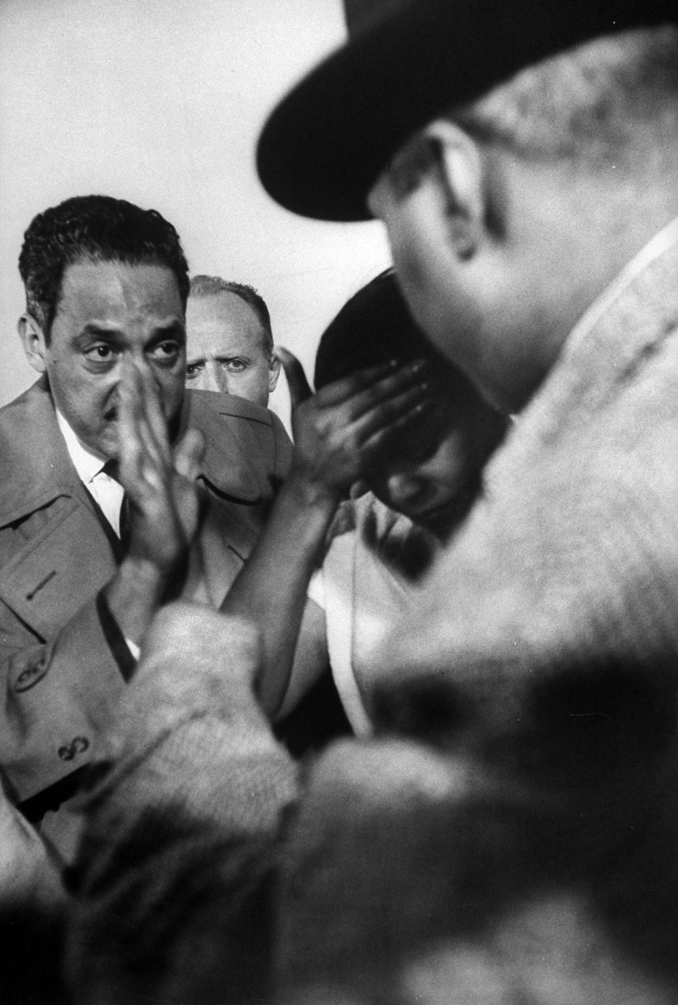 Distraught Autherine Lucy, meeting with the press, as Attorney Thurgood Marshall (L) waves them away, 1956.