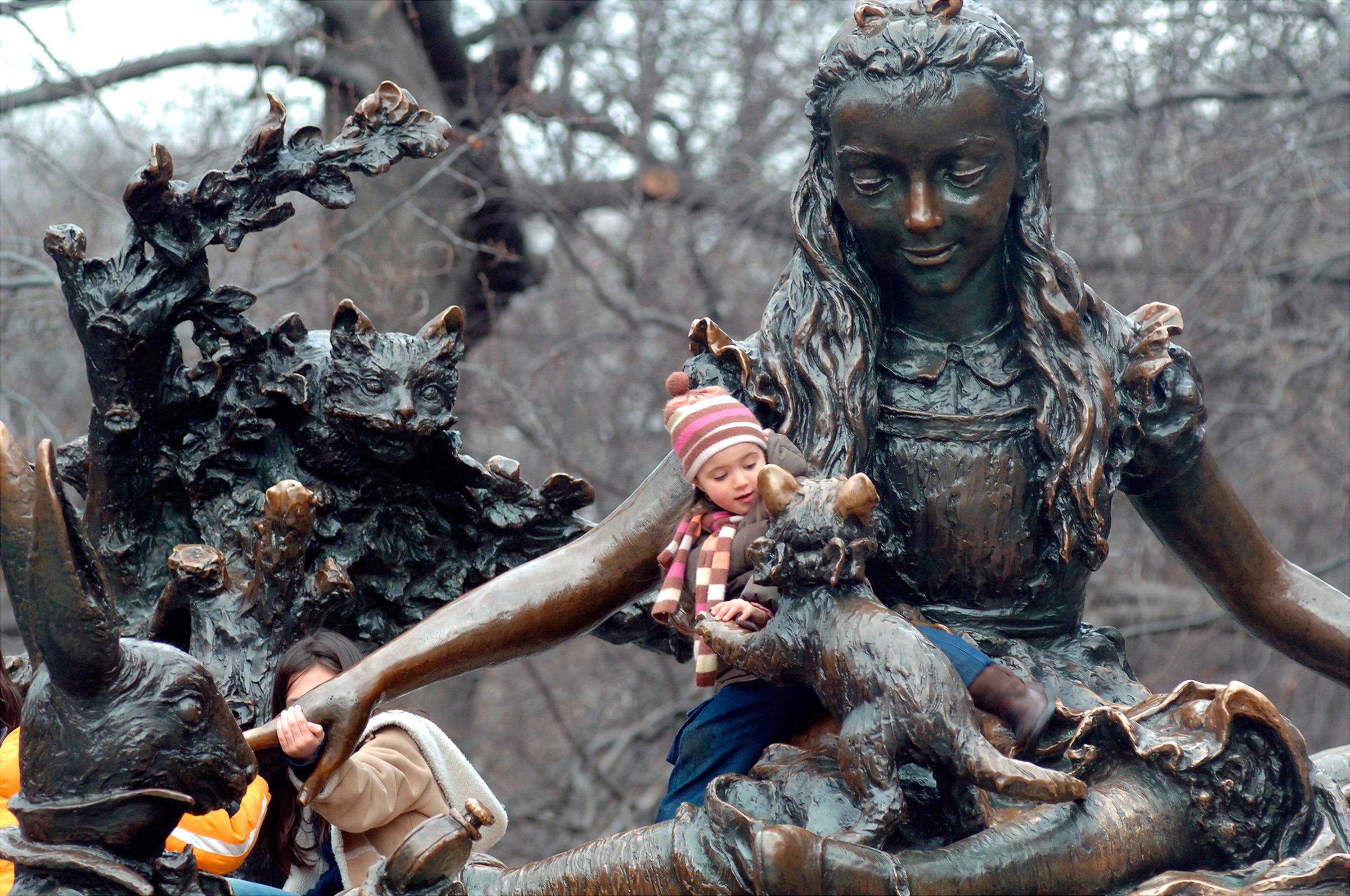 Children play on Central Park’s Alice in Wonderland, one of three monuments to notable women