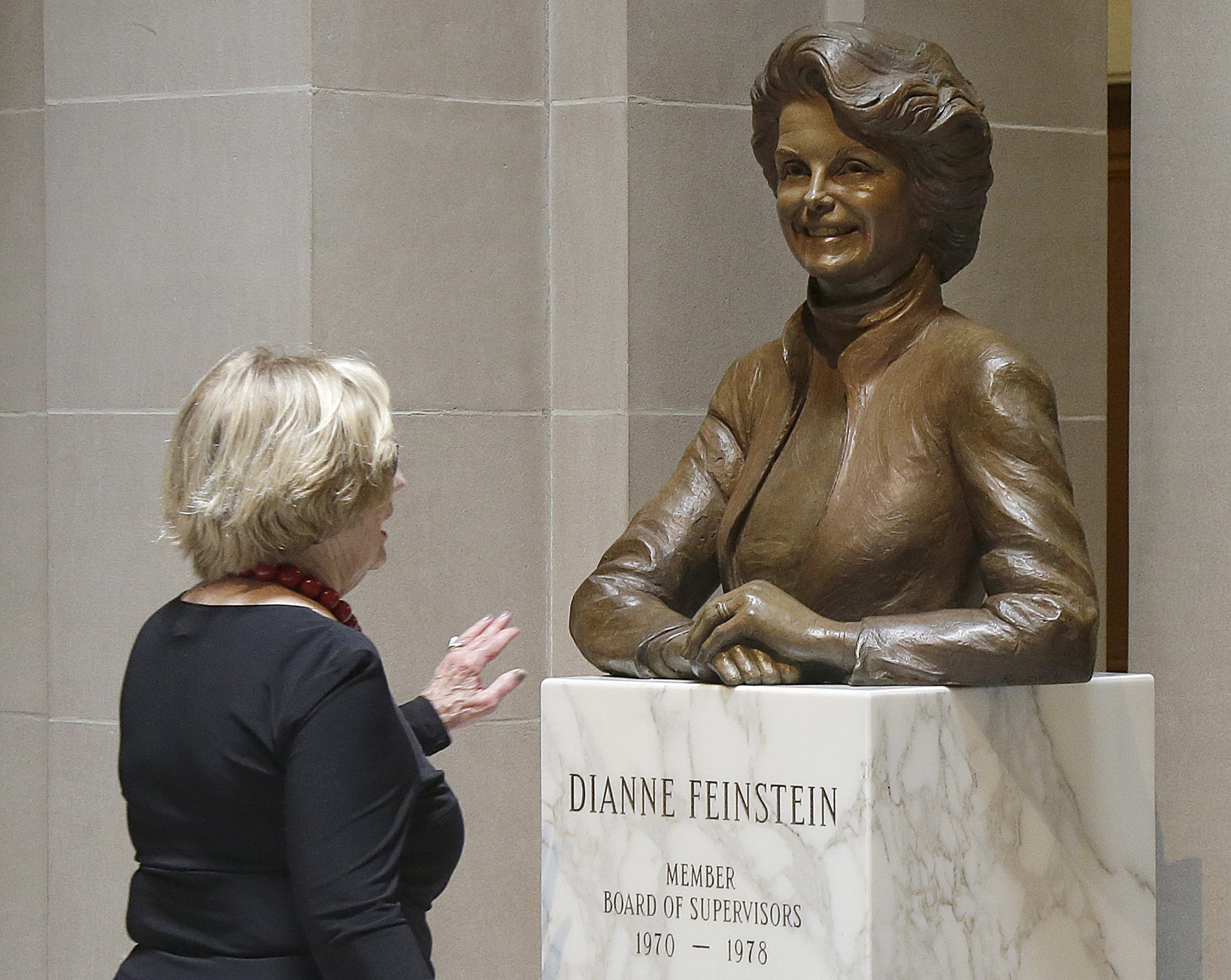 A woman walks toward the statue of Dianne Feinstein at City Hall in San Francisco, on In this June 26, 2017. (Jeff Chiu—AP)