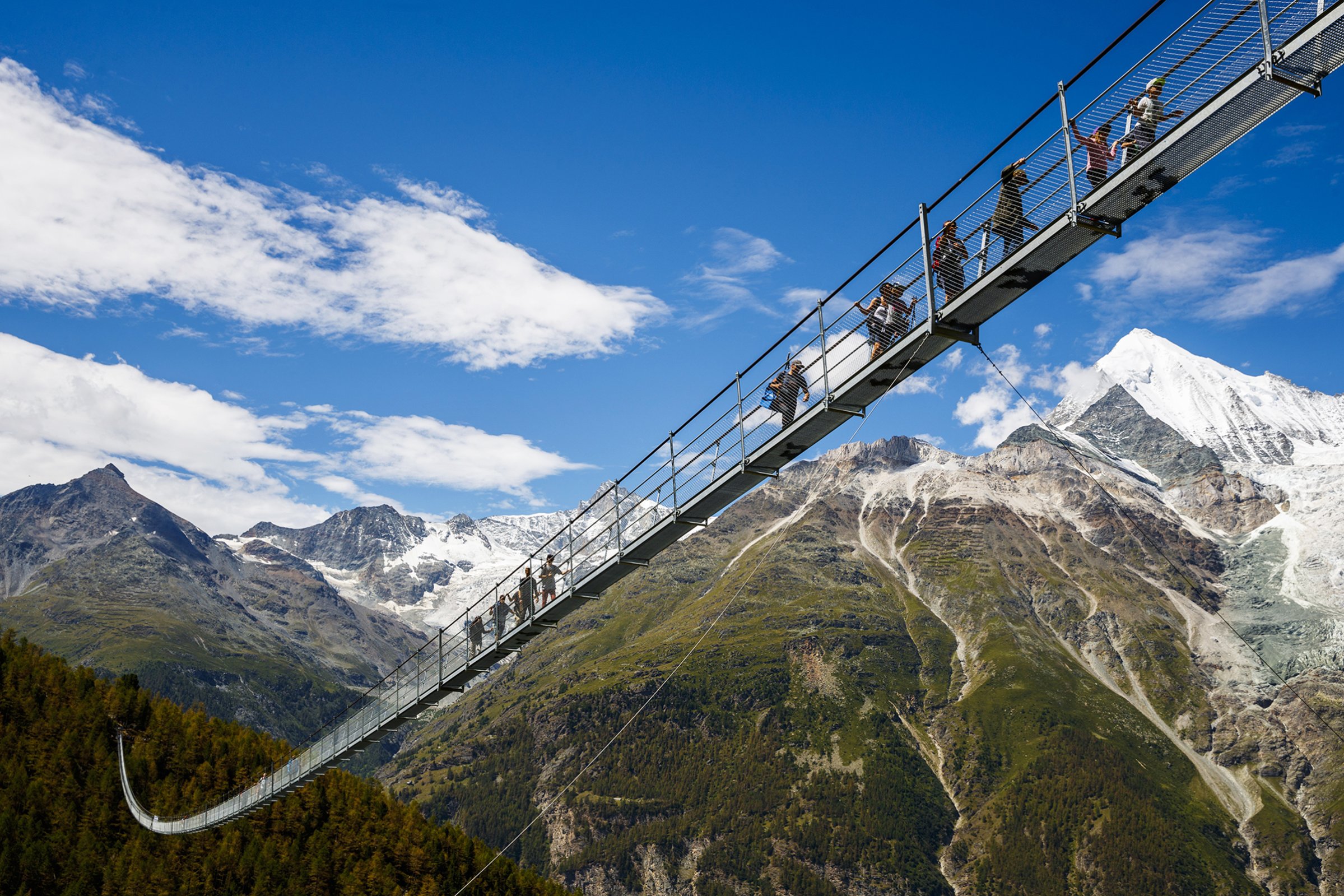 People walk on the 'The Charles Kuonen Suspension Bridge', the world's longest pedestrian suspension bridge with a length of 494m, after the official inauguration of the construction in Randa, Switzerland, July 29, 2017.