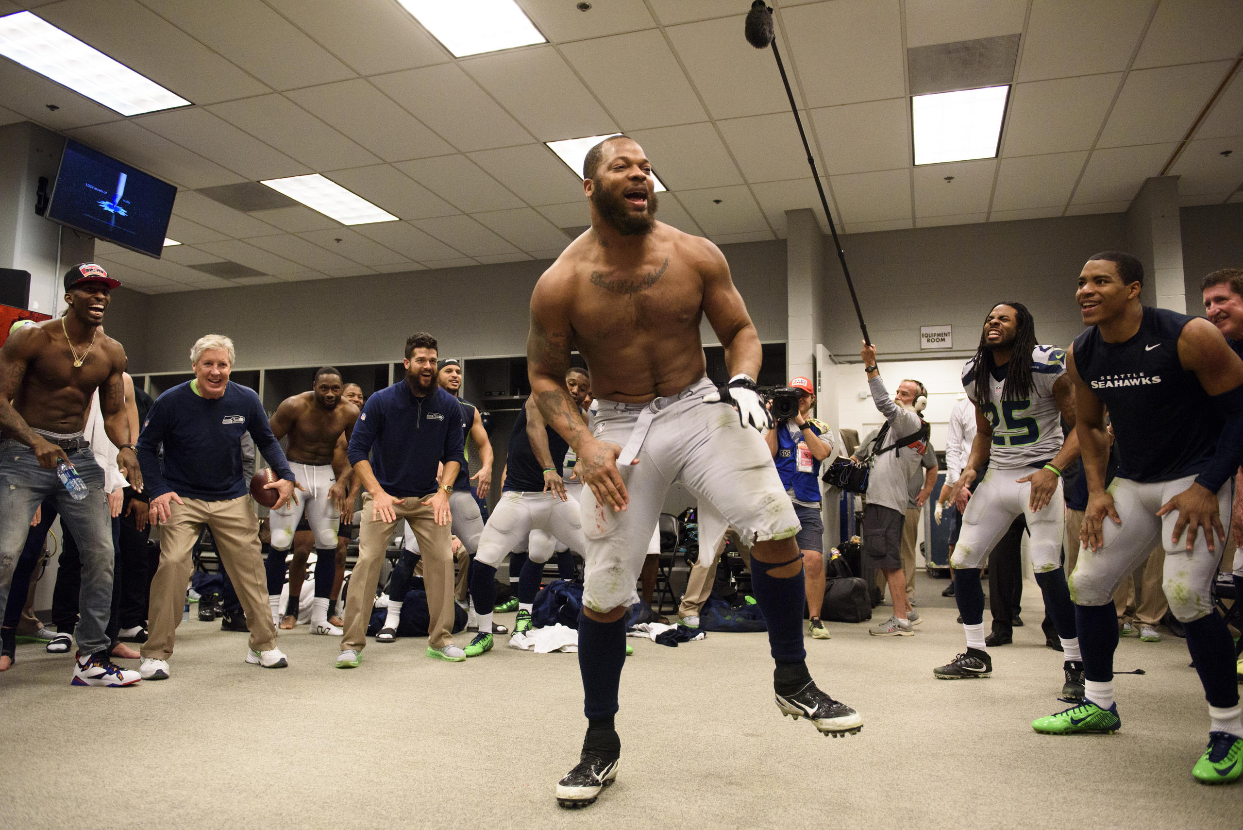 Defensive end Michael Bennett leads the team in the now-traditional post-victory dance in the locker room (Rod Mar/Seattle Seahawks)