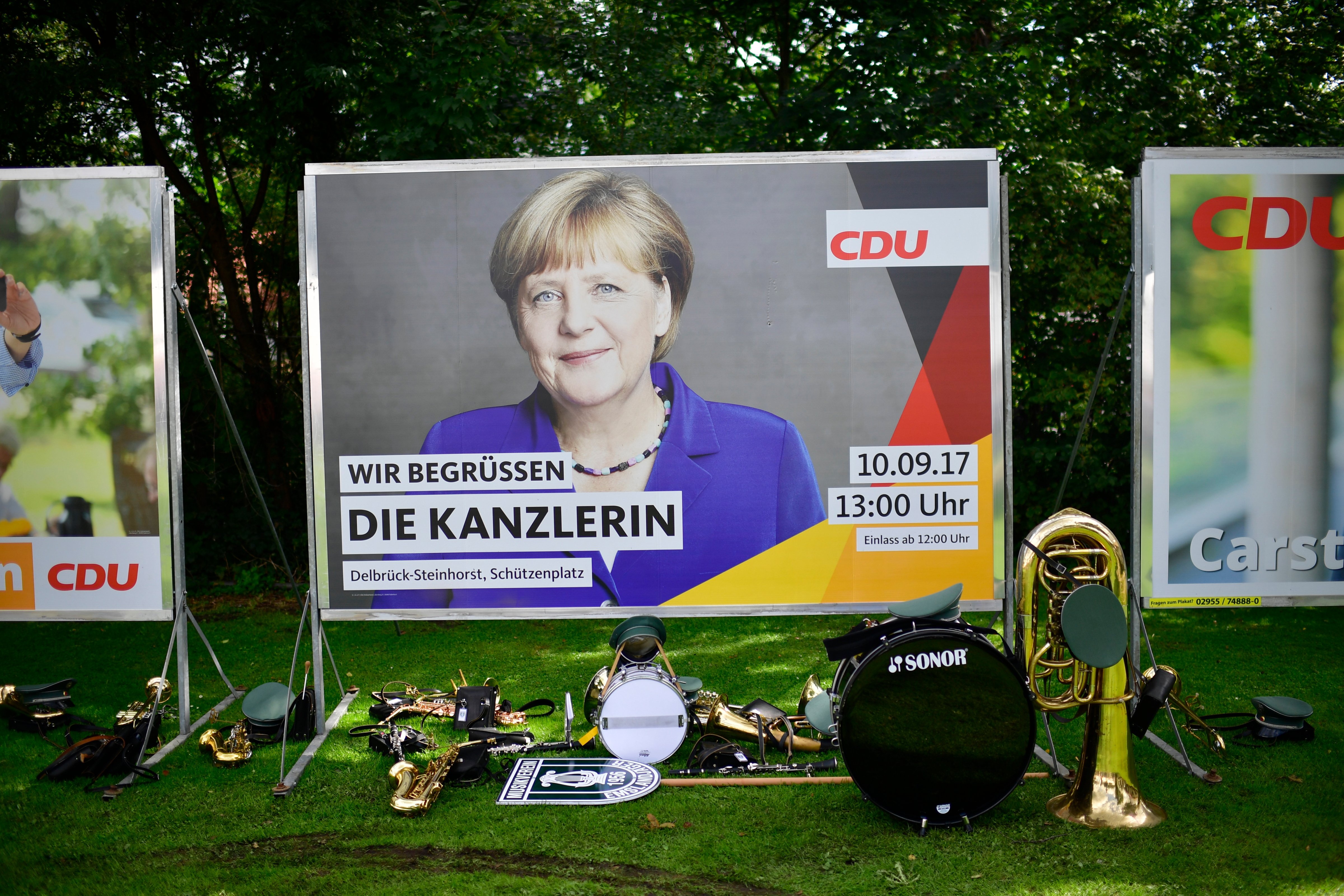 Traditional instruments stand in front of a billboard of German Chancellor and Christian Democrat (CDU) Angela Merkel. (Alexander Koerner - Getty Images)