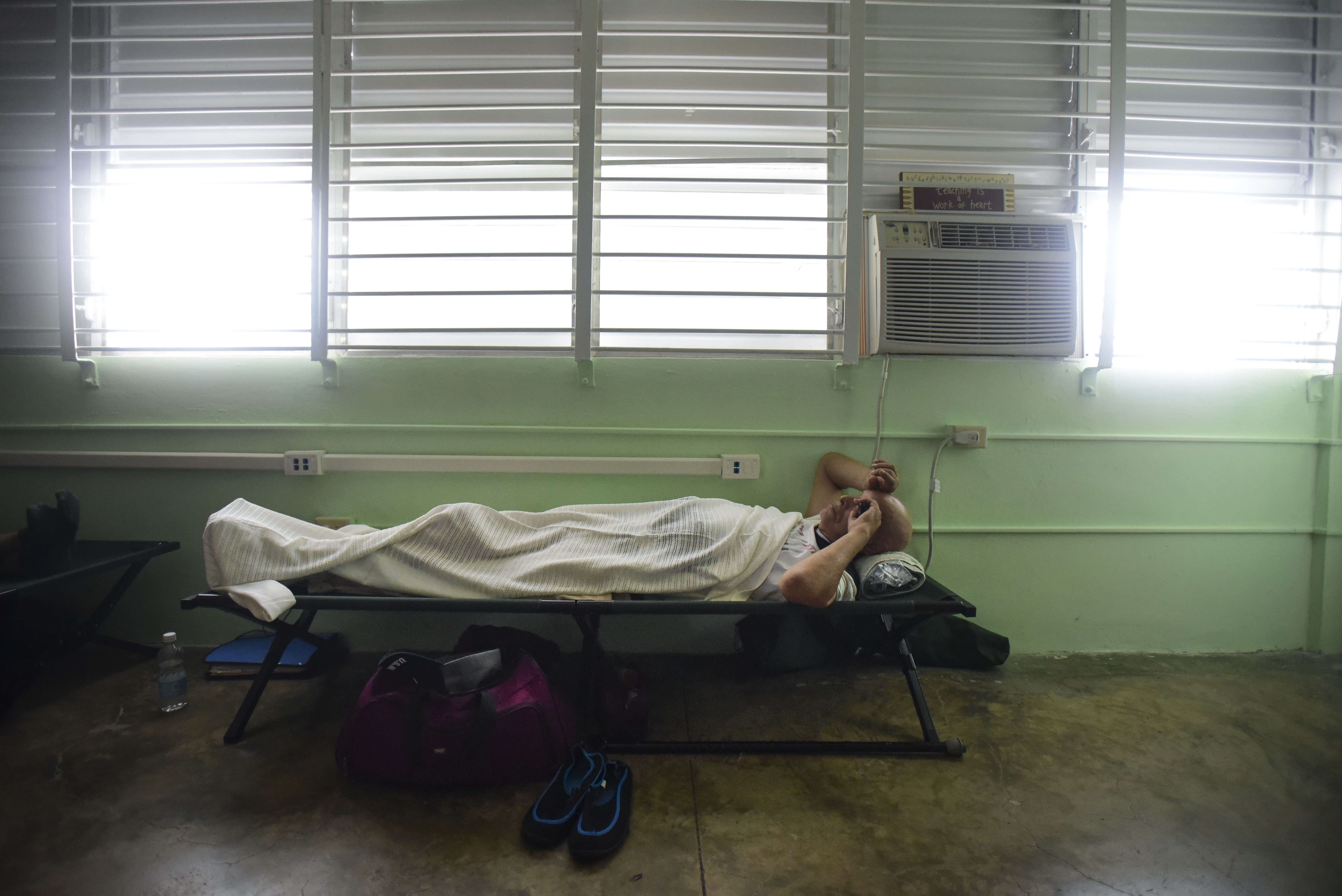 A man rests on a cot inside a shelter set up at the Berta Zalduondo elementary school in Fajardo, Puerto Rico, Wednesday, Sept. 6, 2017.